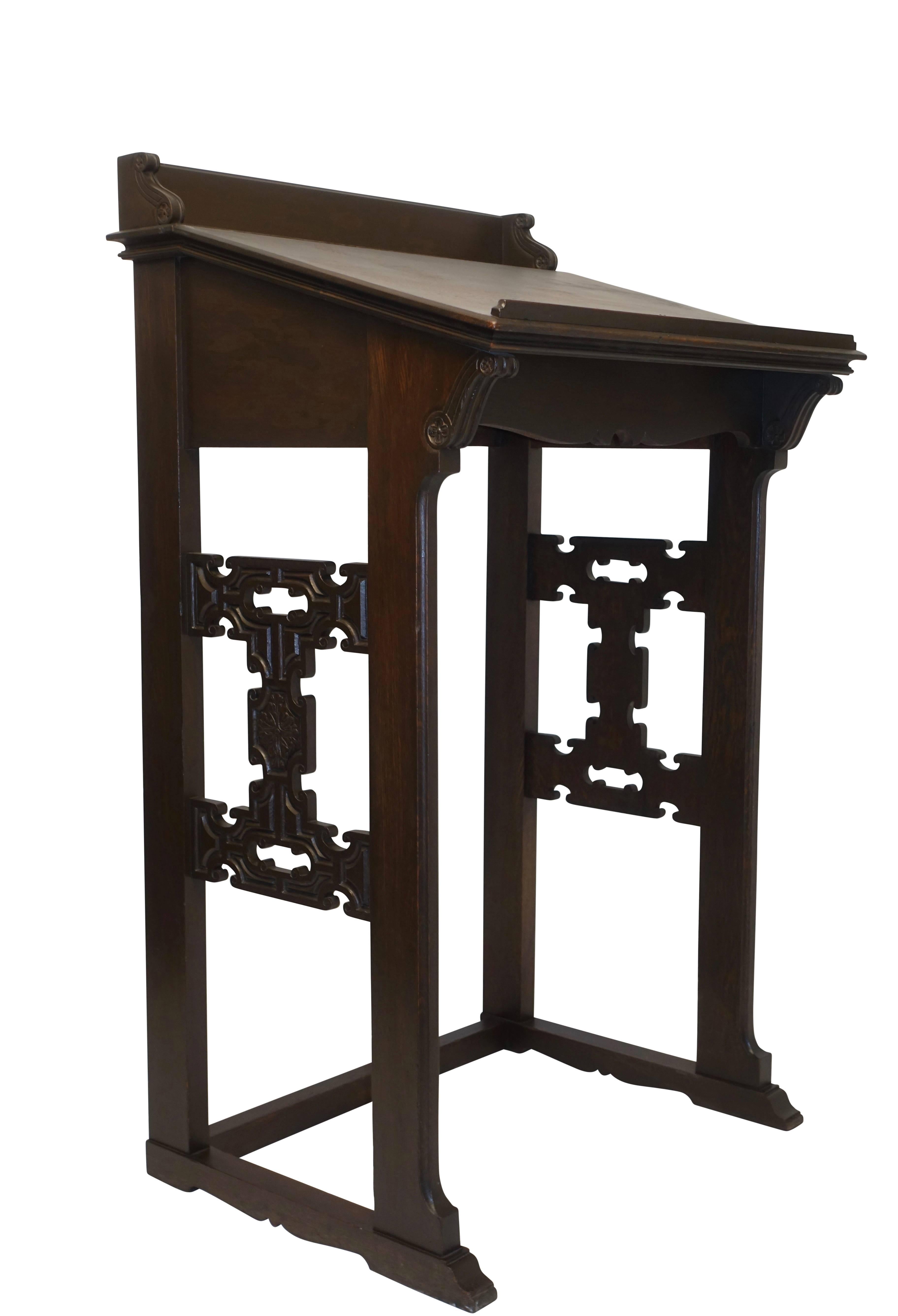 A standing oak podium with molding edges and carved detailing. American, late 19th century.