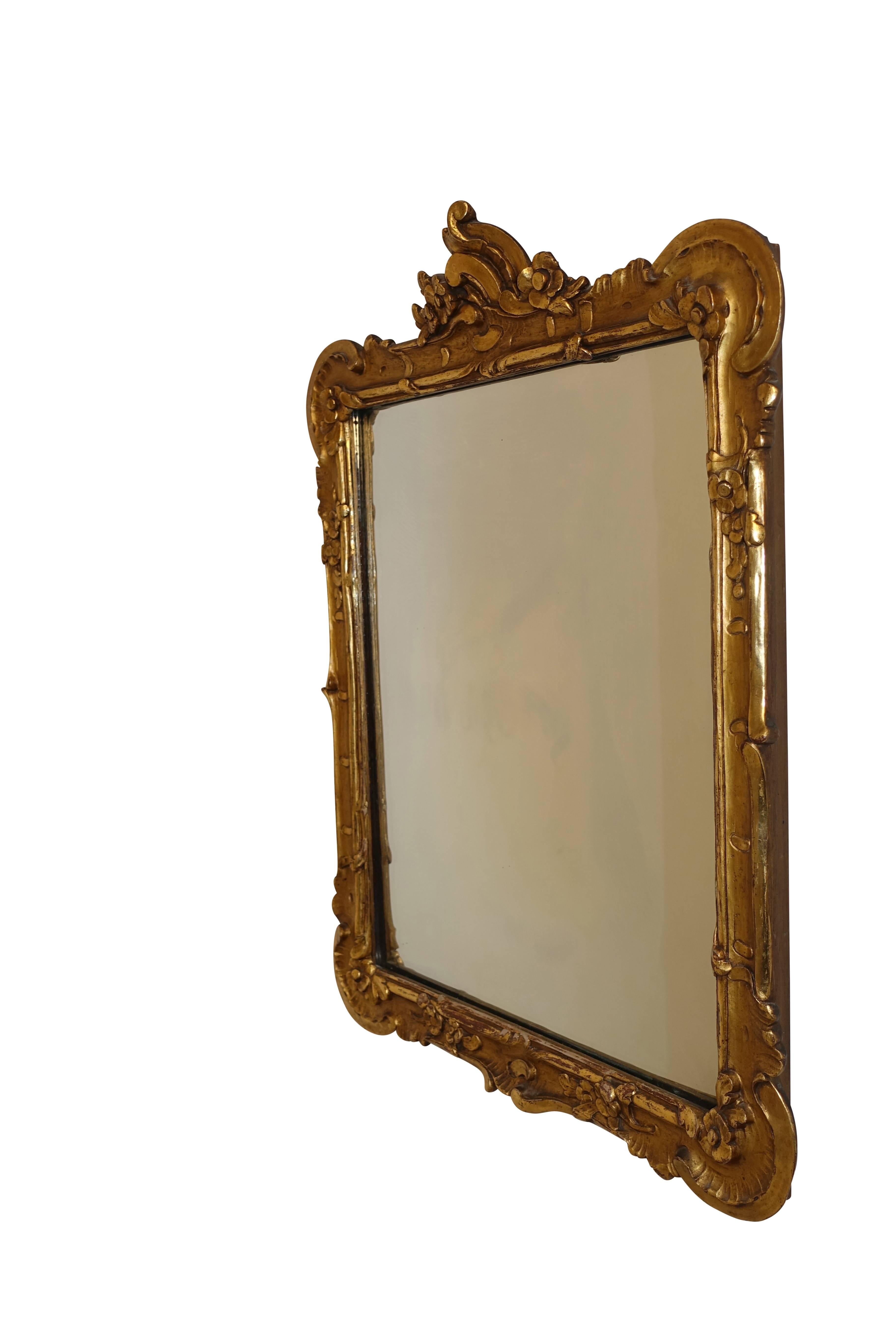 Beautifully carved gilt mirror with C scrolls and flowers surrounding the mirror plate, French, circa 1860.
