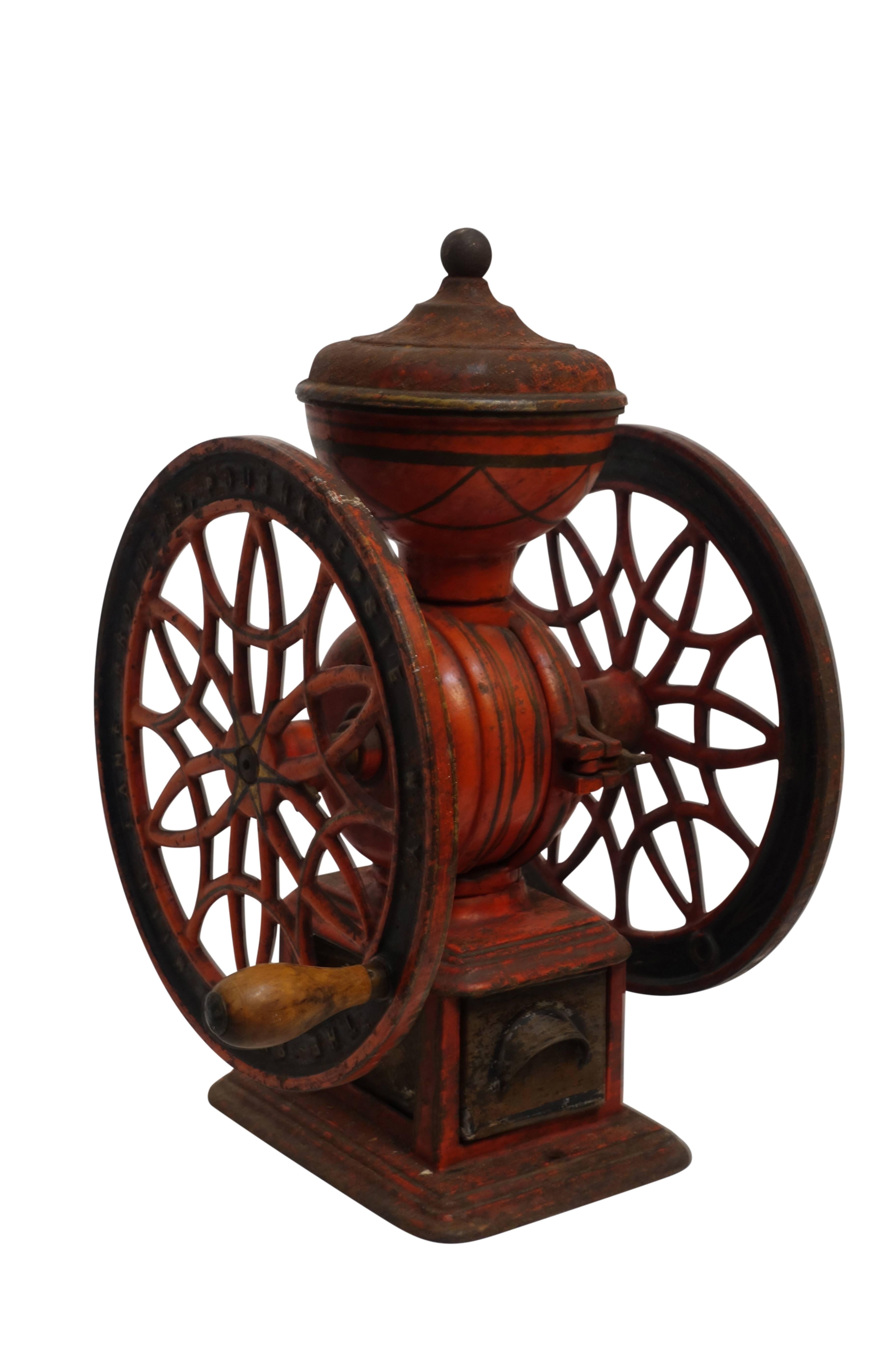 Antique iron coffee grinder with wonderful detail throughout, having original red paint and in original working condition, American, 19th century.