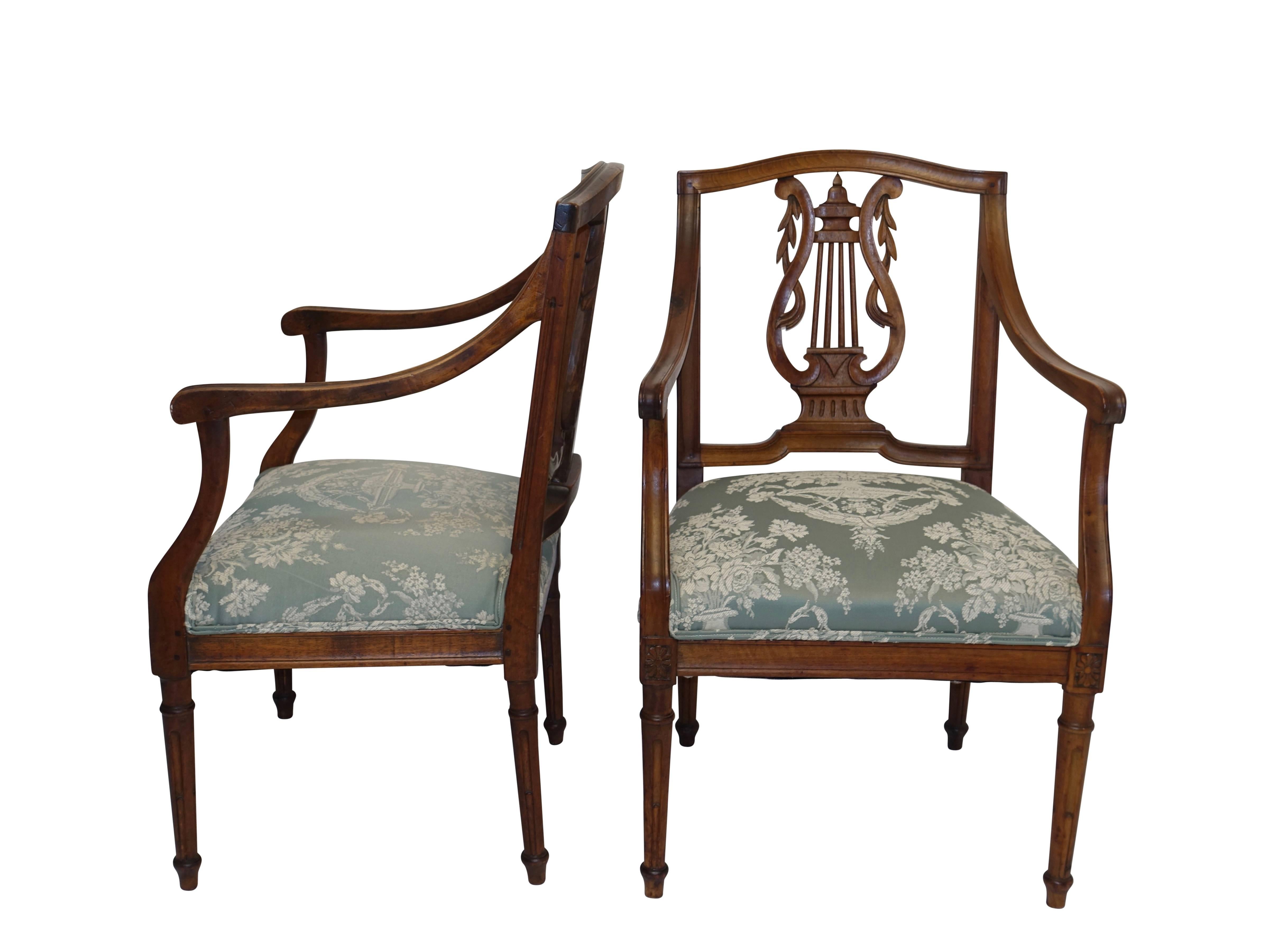 A pair of neoclassical carved walnut fauteuils with carved lyre shape backsplat, sitting on carved and fluted legs. Recently re-upholstered, Northern Italy, 18th century.
