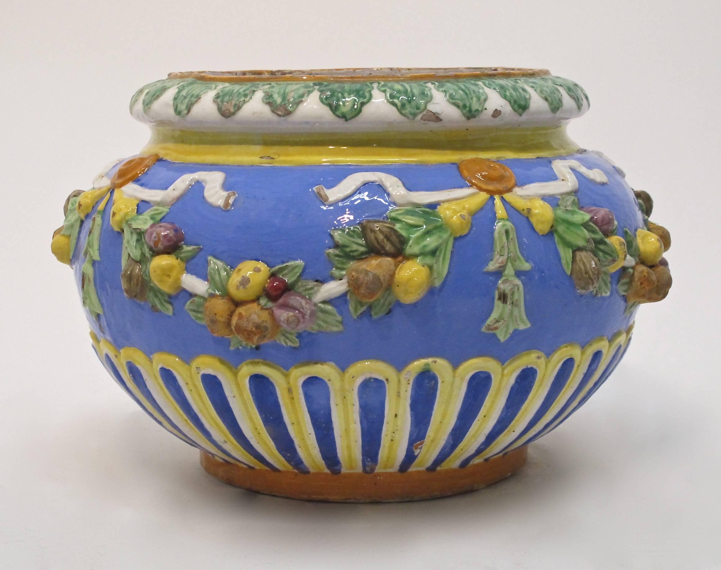 Beautiful old faience or majolica style pot with garlands of fruit and ribbons. Has some expected and minor glaze chips but no damage to the terracotta pot. Italy, late 19th century.