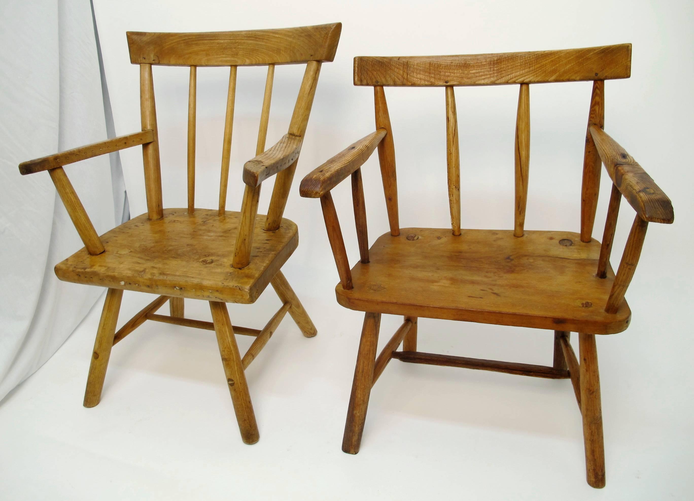 Two unique and charming spindle back arm chairs with plank seats. Made from dense pine wood. Wonderful charm and very comfortable. Both are sturdy and substantial in weight, fitted with red upholstered seat cushions. Bavarian/Alpine, Late 19th.