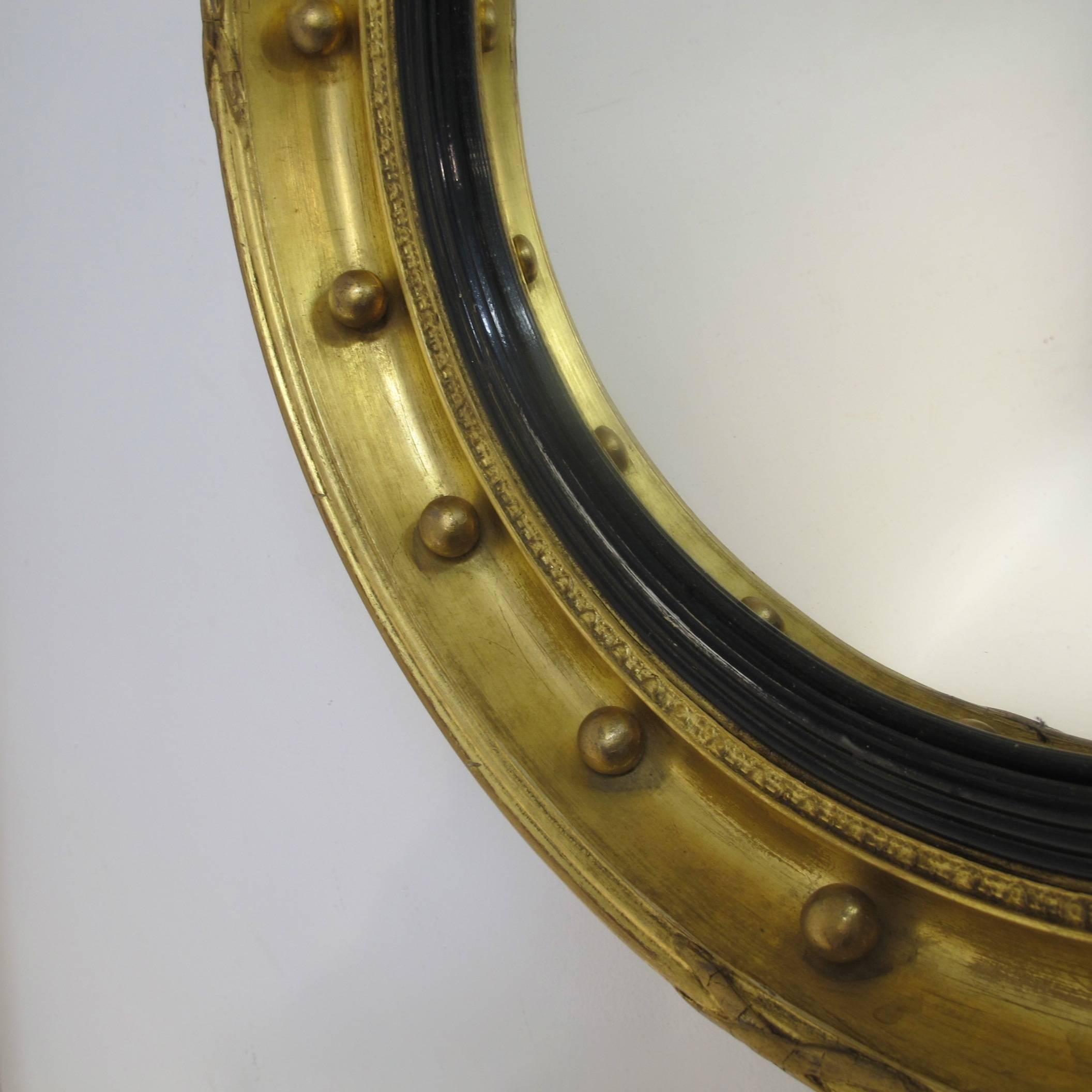 A mid to late 19th century English Regency style small convex mirror with original gilding and original convex glass.