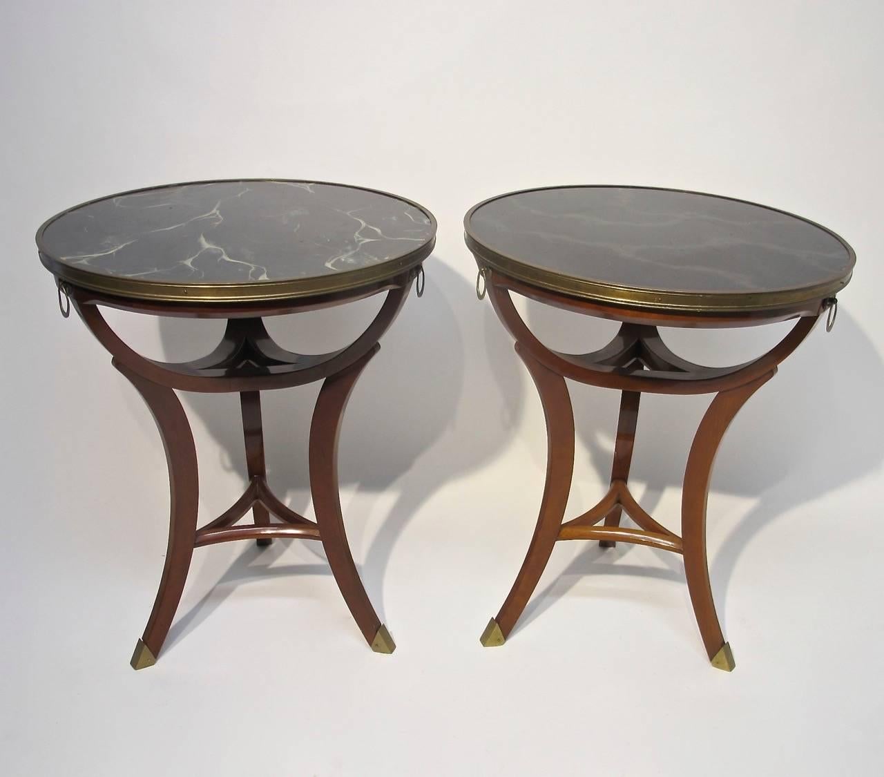 A pair of mid-20th century Widdicomb mahogany end or side tables with solid brass mounts and hardware, and with original inset faux marble formica tops. Tables retain their original Widdicomb labels underneath.
