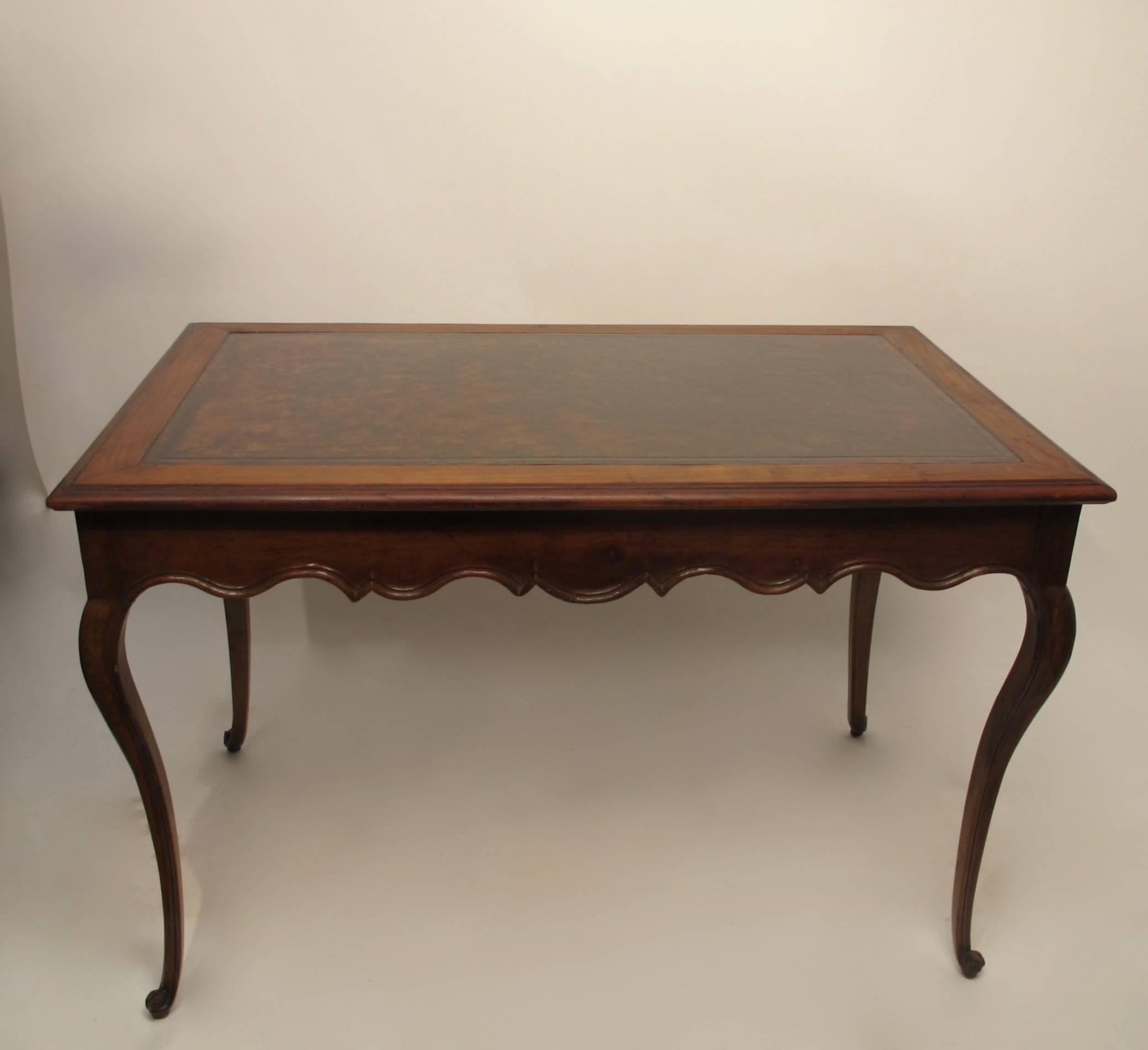 A graceful Louis XVI style carved walnut writing table with inset leather top, having a single drawer at one end. In beautiful condition.
France, circa 1760.