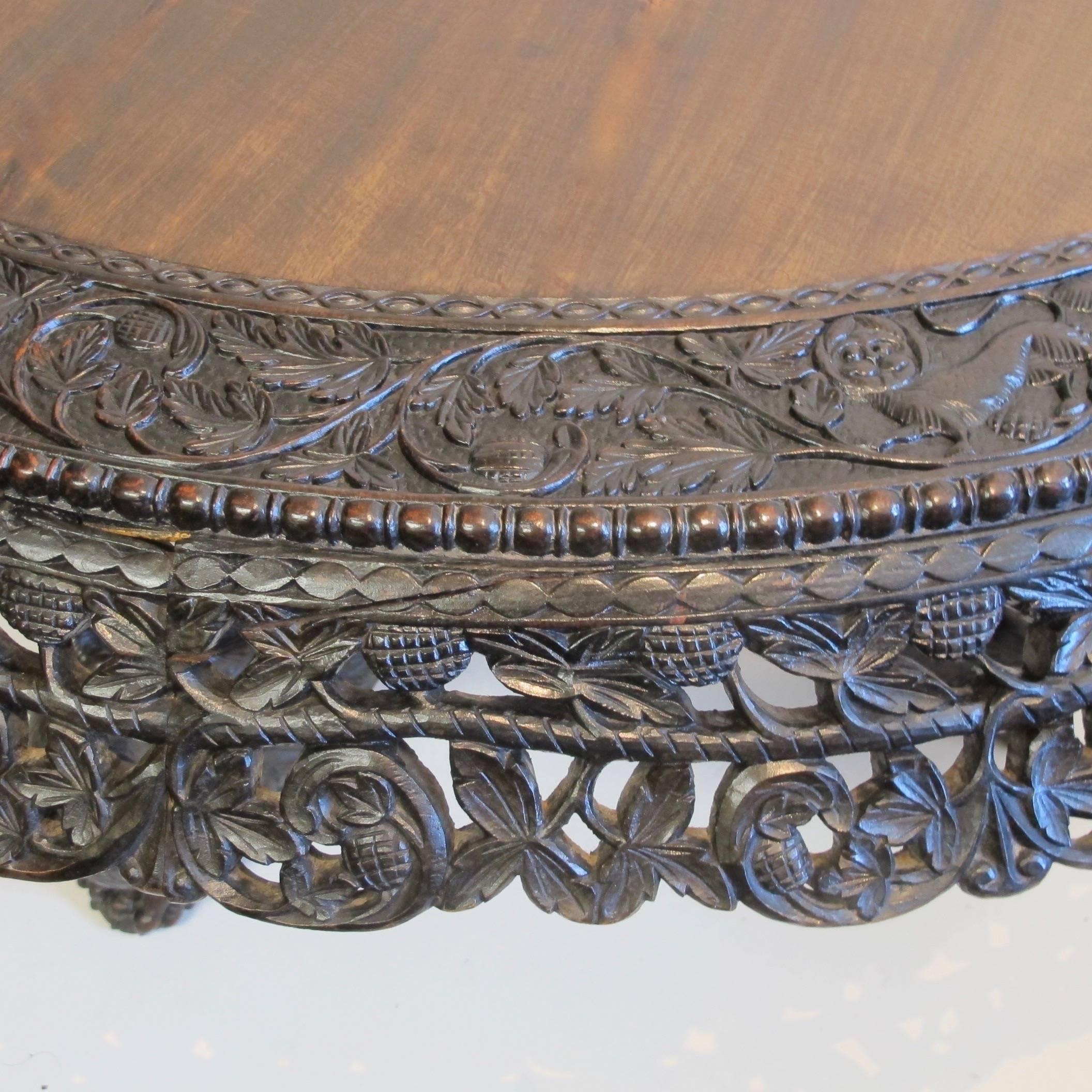 Large scale exceptional and extensively hand-carved Anglo-Indian tilt-top table of padouk wood and rosewood. Having dragons, birds, animals, and an intricately carved frieze, with an inset rosewood center surface.
Indian, mid-19th century.