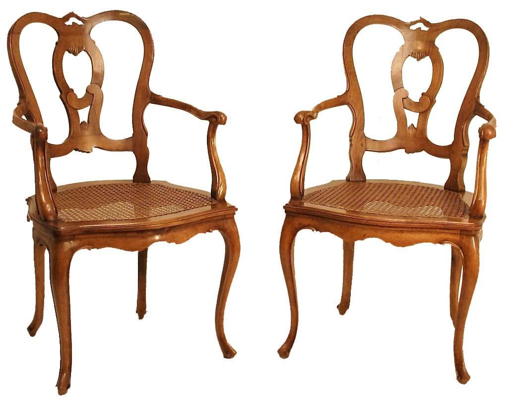 A pair of fine quality and beautifully carved walnut armchairs with caned seats. These chairs have a nice generous size seat, and are sturdy and sound. Cushions are in good condition, ready for upholstery, Italy, mid-20th century.