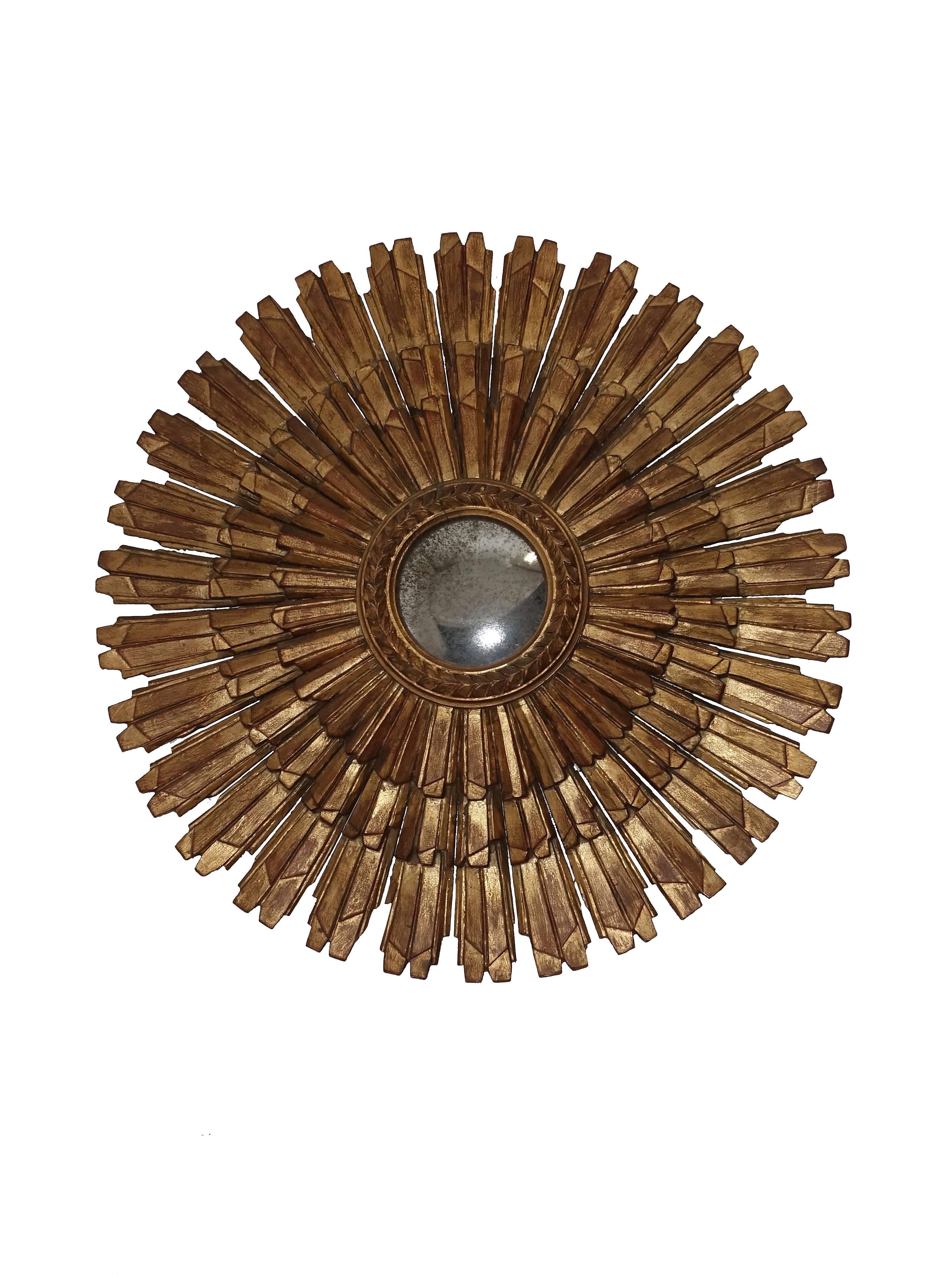 Carved and giltwood sunburst with convex mirror, marked on the back Palladio.
Italy, mid-20th century.