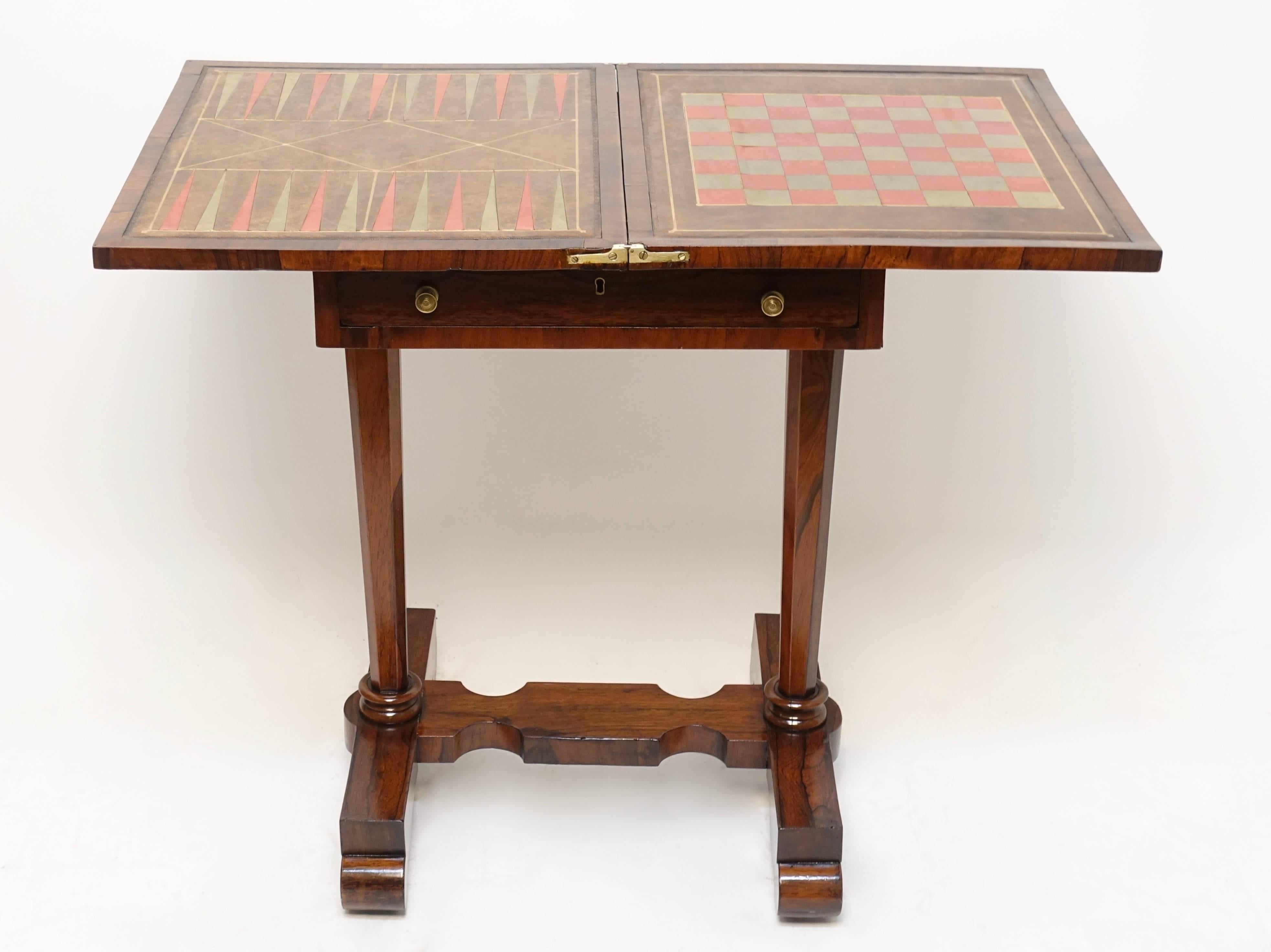 Rosewood side table with a single drawer and inset leather gaming surface. The swivel top opening to a leather lined games board for chess and backgammon. When fully open the table measures 34 inches wide, England, circa 1830.