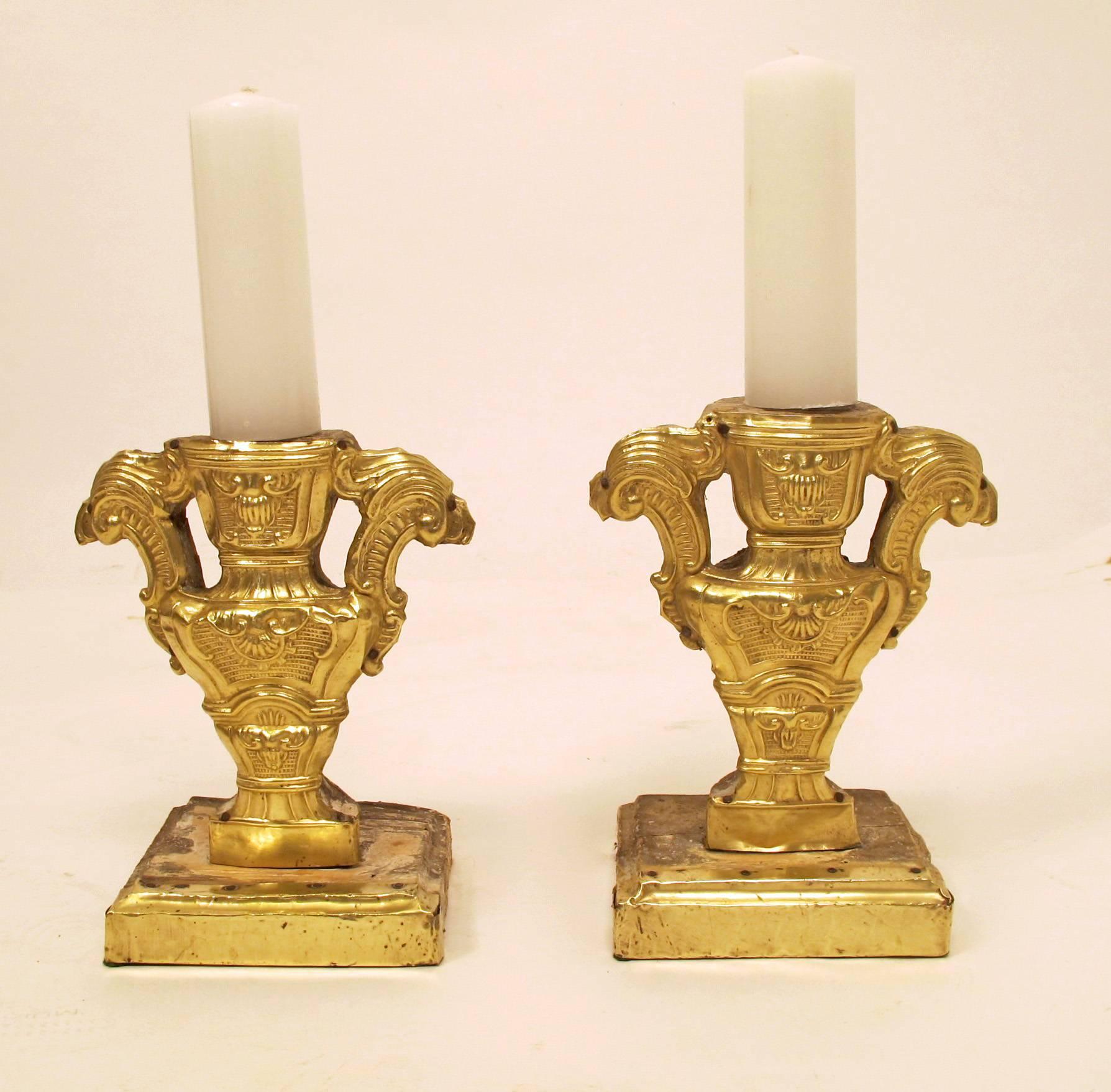 Pair of outstanding 18th century brass over wood (repousse) pricket candleholders. Wood is hand-carved and painted, with the fronts covered (repoussed) in brass. Candles are placed on an iron spear on the top of each holder. (Candleholders with
