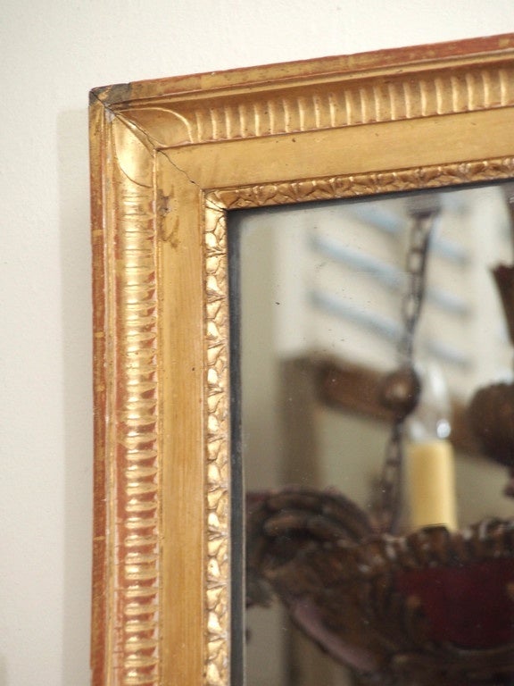 A 19th century giltwood mirror, the glass in two parts and the frame gilded and with simple leaf-form corners.