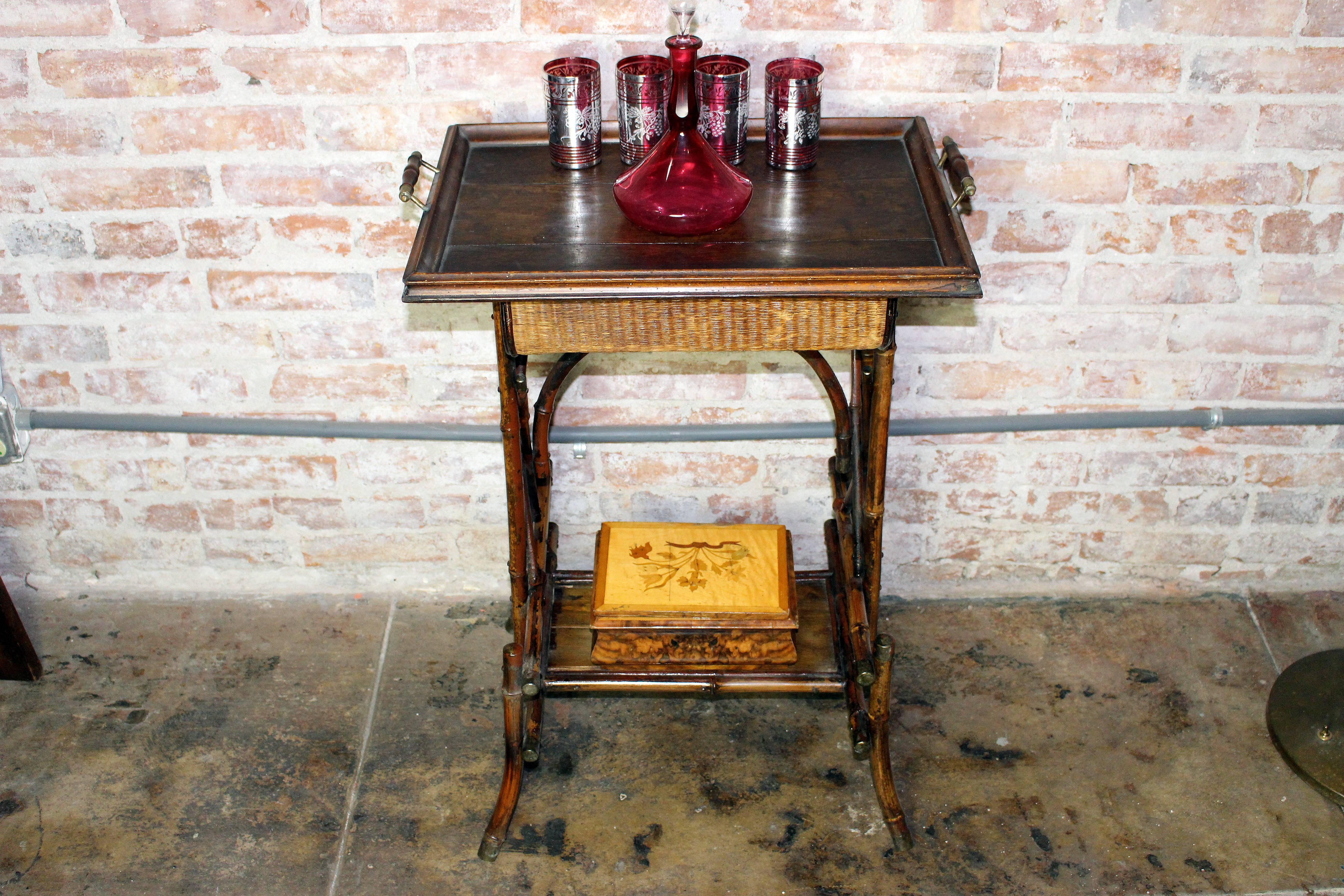 1900s British Colonial cocktail table in original condition. Bottom shelf antique cigar box inline wood work gorgeous. Top shelf wooden tray with antique bohemian sherry bottle. Glasses are newer date and gorgeous. Burgundy silk cover like shown in