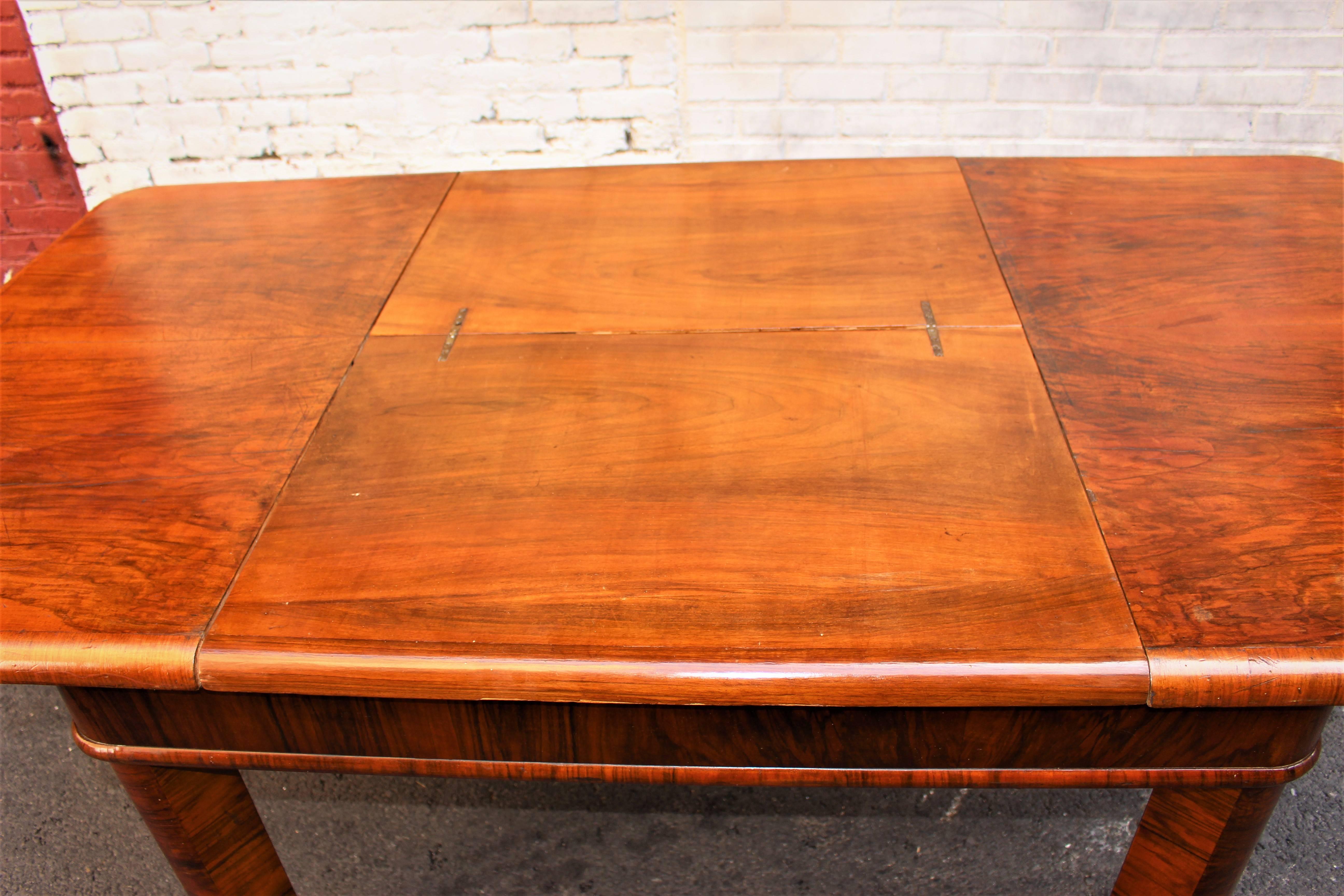 French Art Deco table, the drop leaf fold up under the table and it is invisible table full extended is 81 inches. Table seats 6 to 8 people. 
Walnut base and veneer.