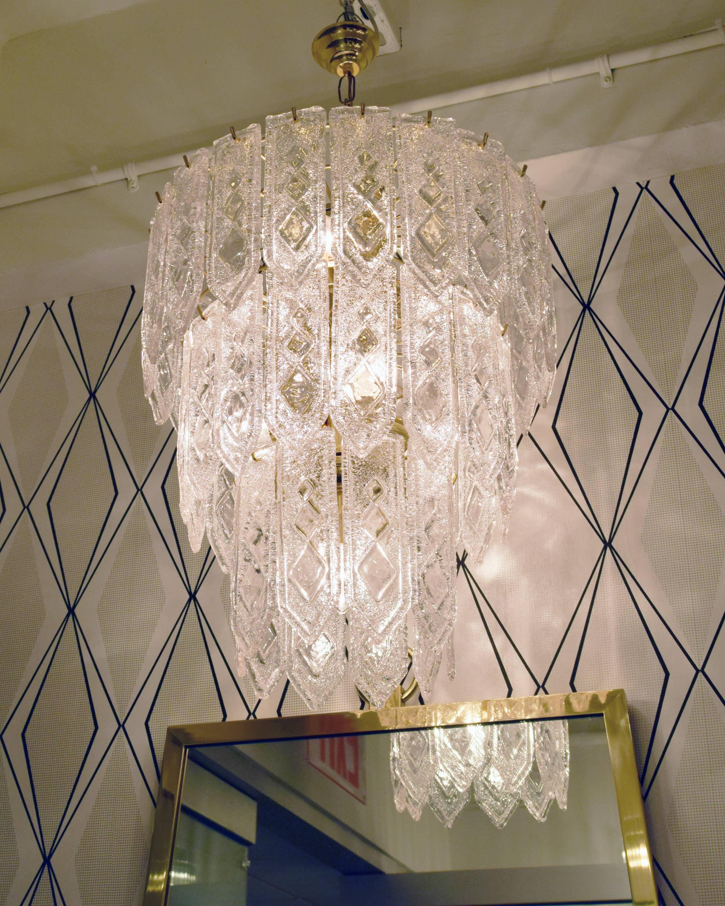 A pair of three-tiered wedding cake blown glass Italian chandelier in the style of Venini. The chandelier sconce has 46 crystals that have an Art Deco geometric pattern on them. All crystals in perfect condition. The chandelier can hold up to 360 W.