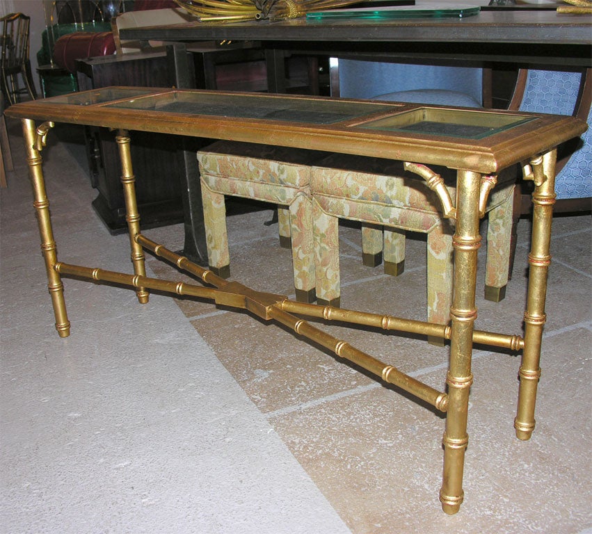 Faux bamboo gilt console or sofa table, with glass inset tops. Distressed finish with gold worn in spots revealing the red under color with a good bit of patina on entire piece.