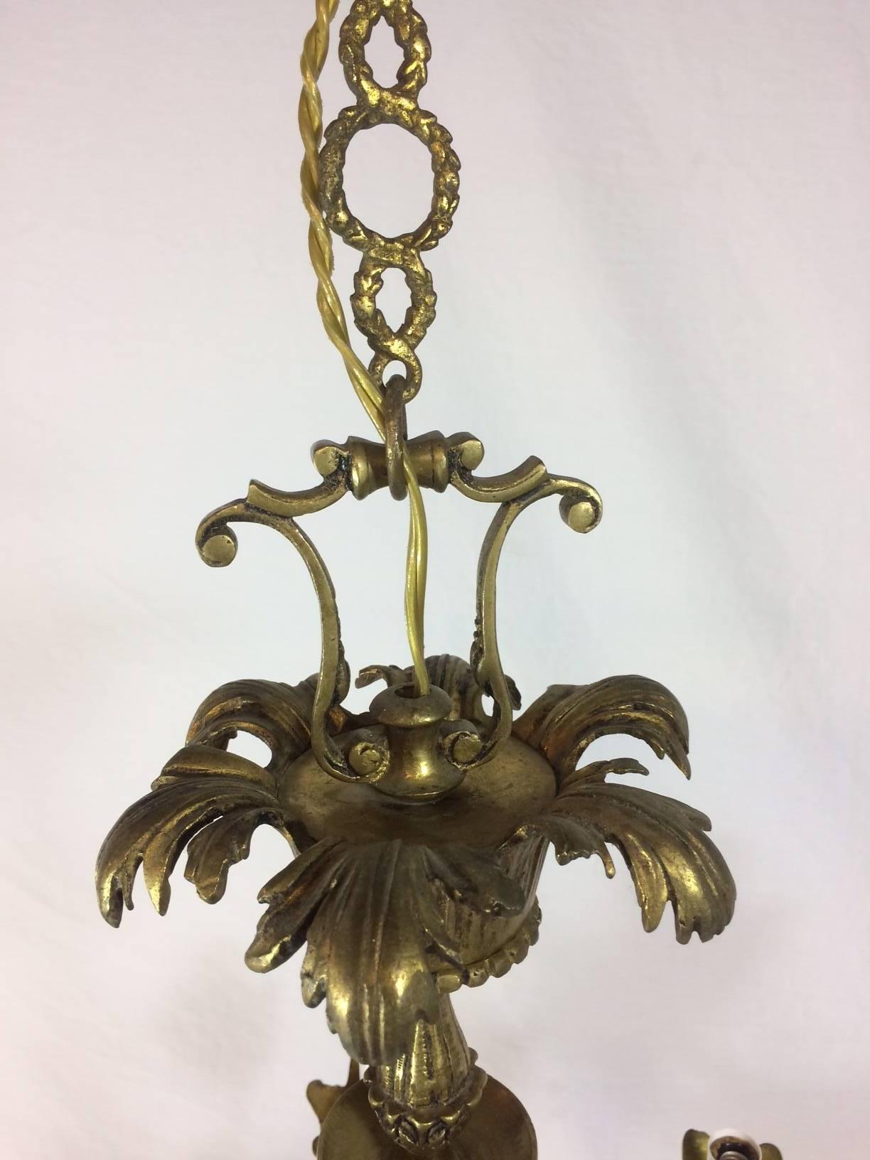 Six-arm Empire style ram's head chandelier. Solid brass and heavy. Has great patina. In working condition.  Will be professionally packed and shipped. Price based on destination.