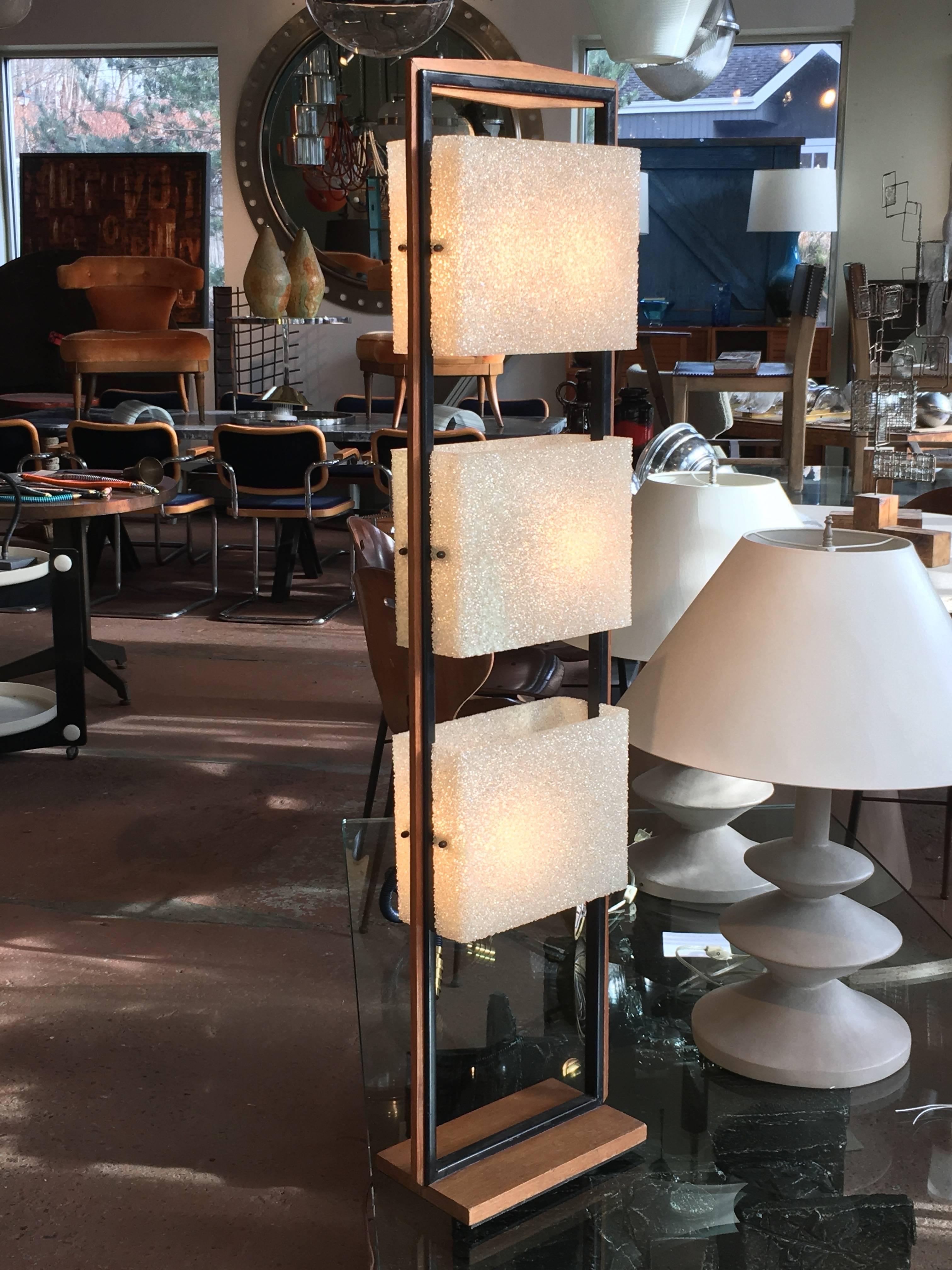 French Mid-Century floor lamp produced by Maison Arlus; teakwood and black painted metal linear tower structure with three acrylic shades; total of six bulbs, two within each shade.