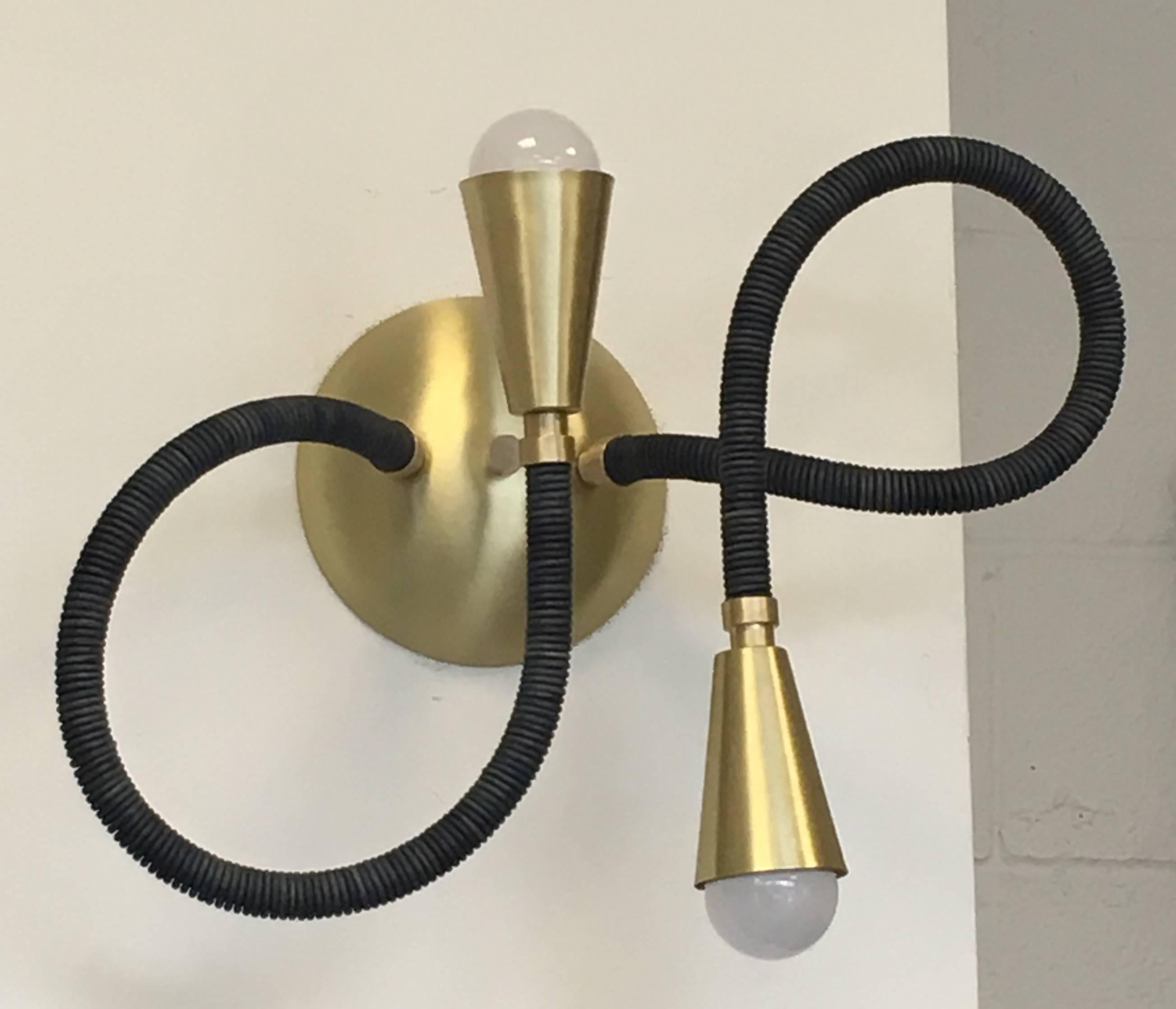 Brass and leather wrapped meander wall or ceiling mounted light fixture, shown in natural blue indigo leather and brushed brass. Adjustable arms allow for your own stylish poses. Available in custom leather colors and metal finishes, standard