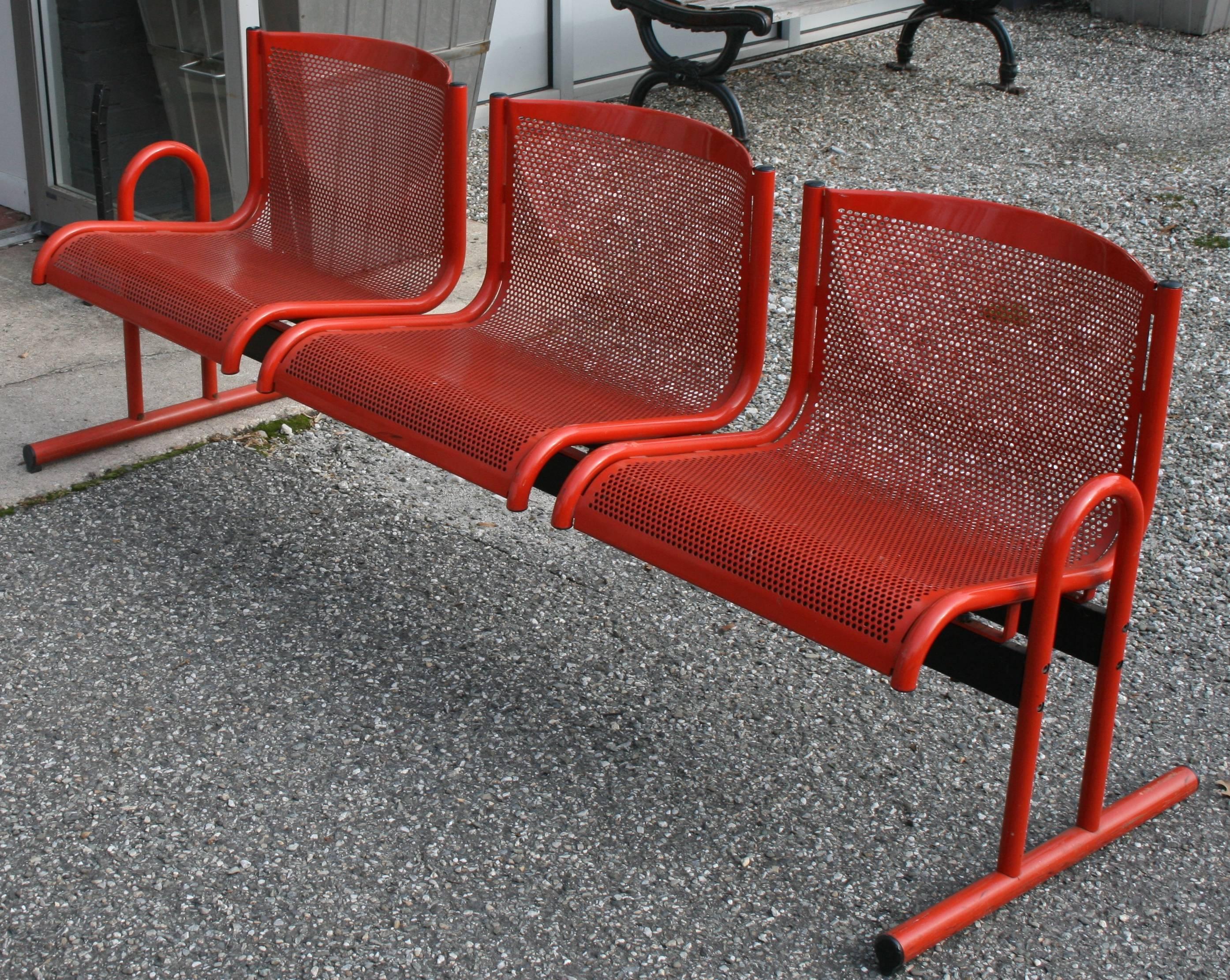 Bench in the style of Jean Prouve, French tubular and pierced metal three-seat bench, original red paint.