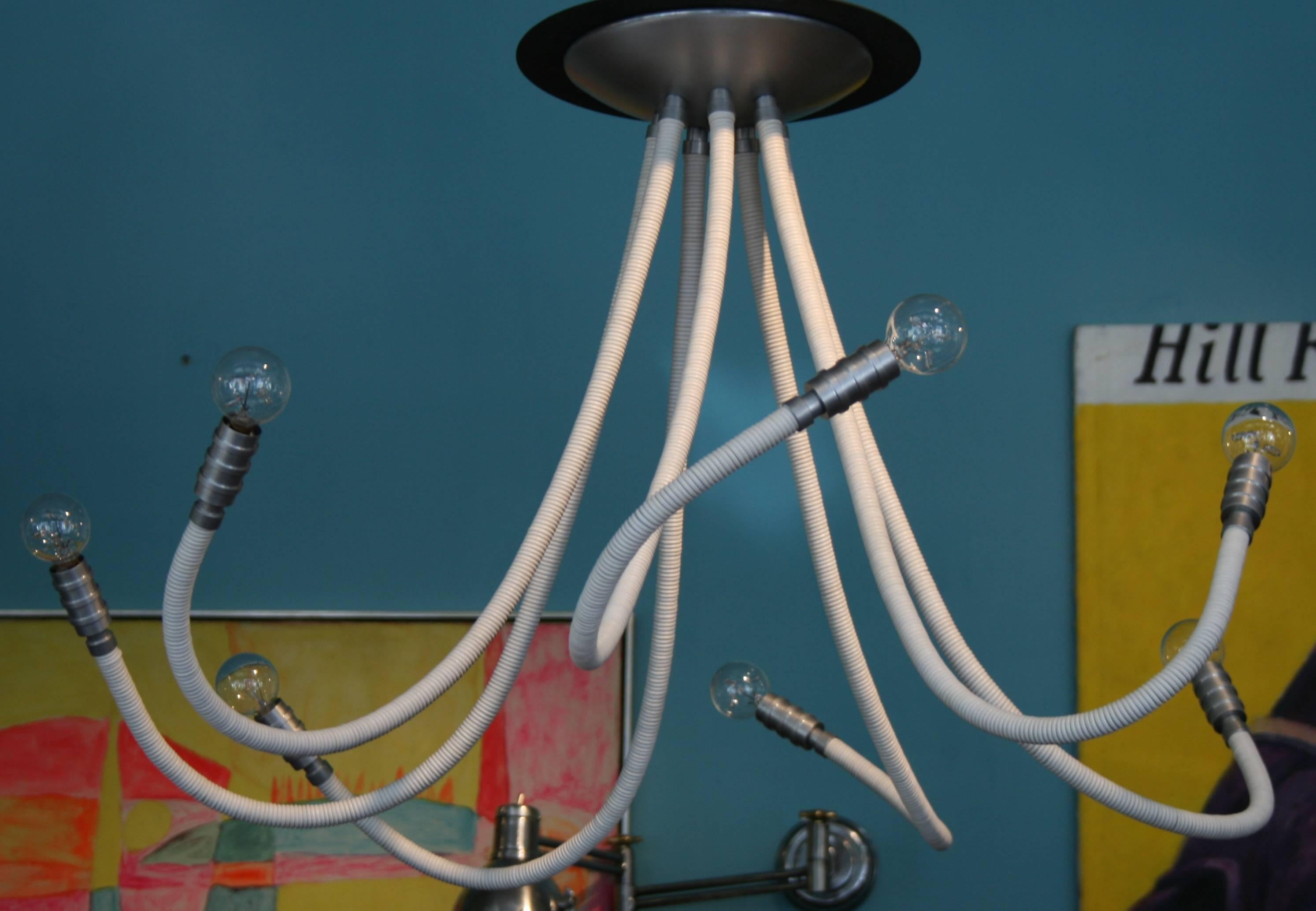 Matte metal chandelier with seven adjustable arms wrapped in white leather. Also available in other colors, metal finishes and custom configurations.

Avantgarden Ltd. cultivates unexpected and exceptional lighting, furniture and design.  To view