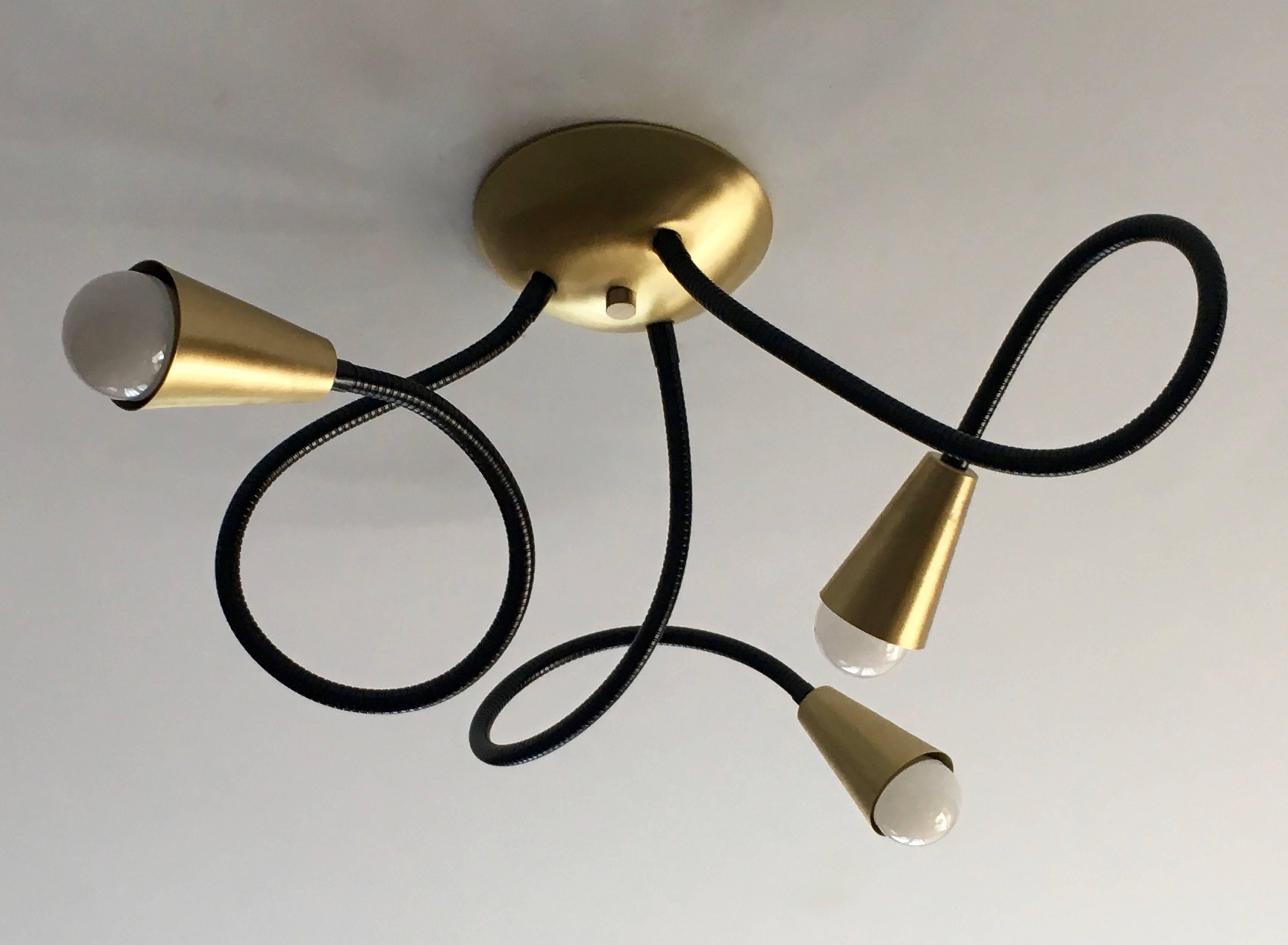 Ceiling mounted Meander light featuring three flexible arms which allow you to adjust and pose the light fixture; shown here with metal arms in standard black finish, and solid brushed brass fittings; 27 inch arms, 6 inch diameter ceiling mount.