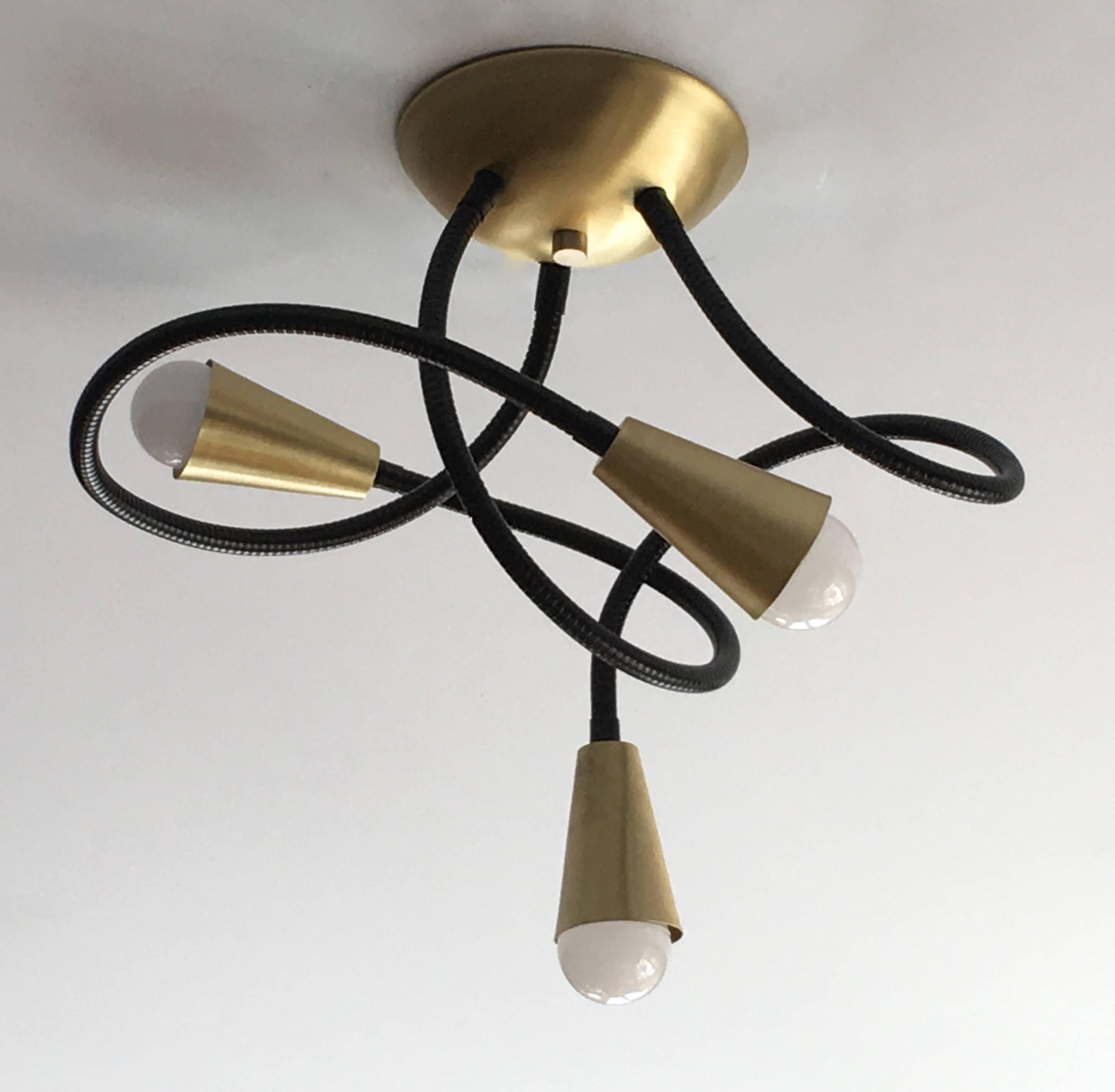Ceiling mounted Meander light featuring three flexible metal arms which allow you to adjust and pose the light fixture; shown here with metal arms in standard black finish, and solid brushed brass fittings; 27 inch arms, 6 inch diameter ceiling