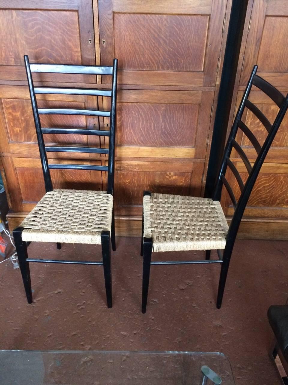 Pair of Gio Ponti high ladder back chairs, lacquered black wood frames with with rushed seats.

Avantgarden Ltd. cultivates unexpected and exceptional lighting, furniture and design.  To view items in person please visit our showroom in Pound Ridge,