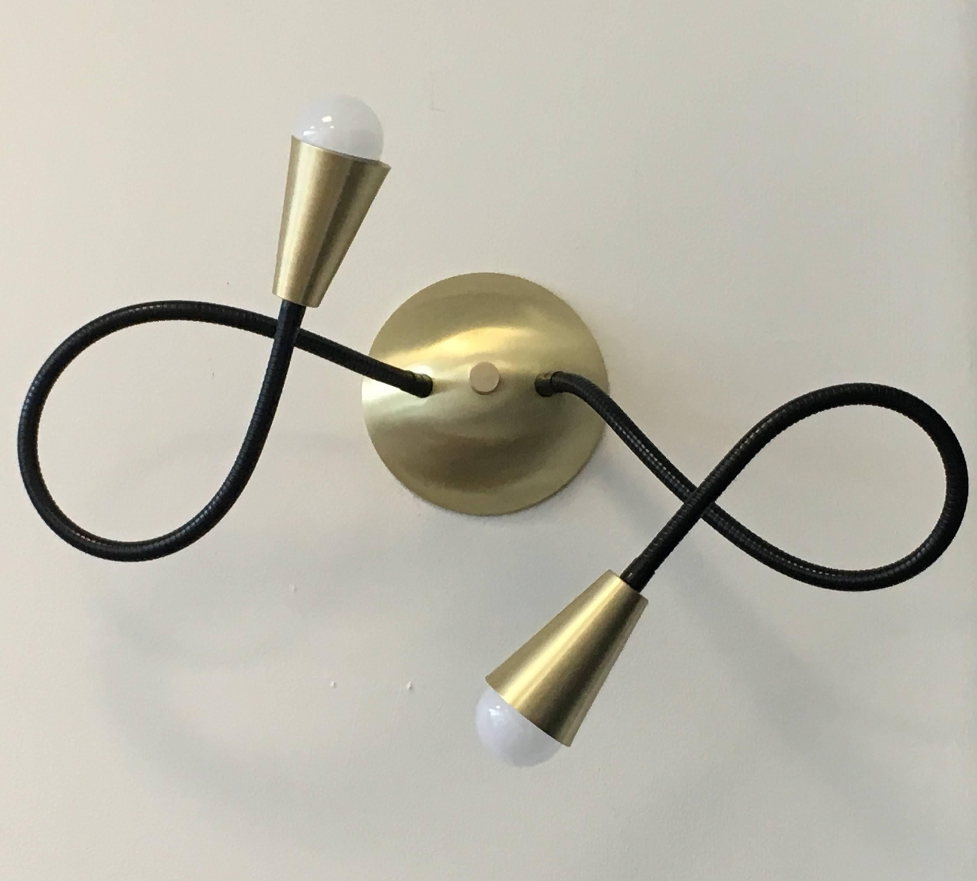 Meander wall sconce with two flexible metal arms, which allow for playful movement and endless poses. Shown here with our standard black metal flex arms and brushed brass fittings. Arms are 26 inches long, but overall measurements vary on how you