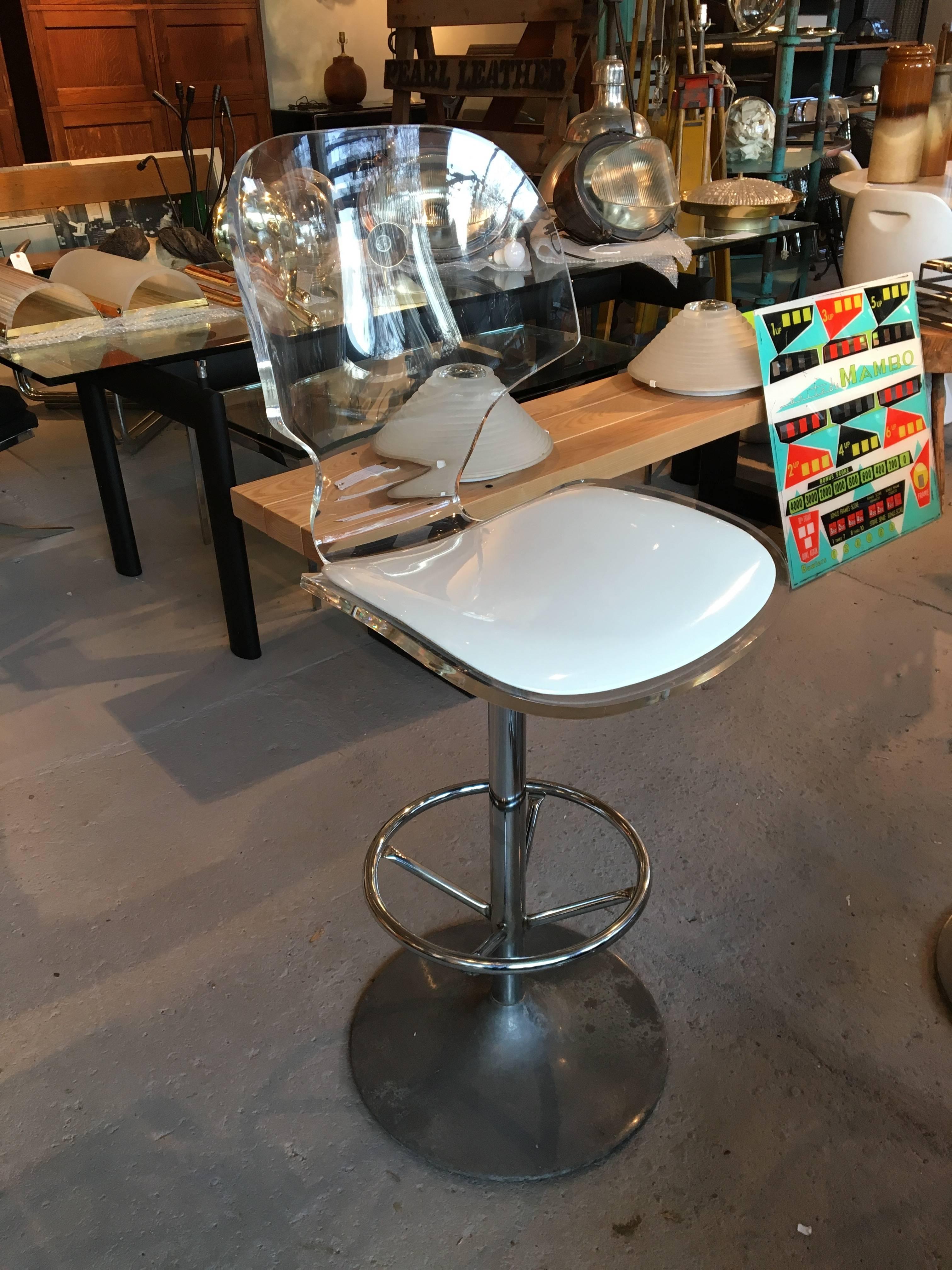 set of 3 Lucite swivel barstools by Hill Manufacturing Corp, with clamshell shape seat, white patent leatherette seats, chrome footrests, and aluminum tulip style bases that have great natural patina but can be polished if desired.