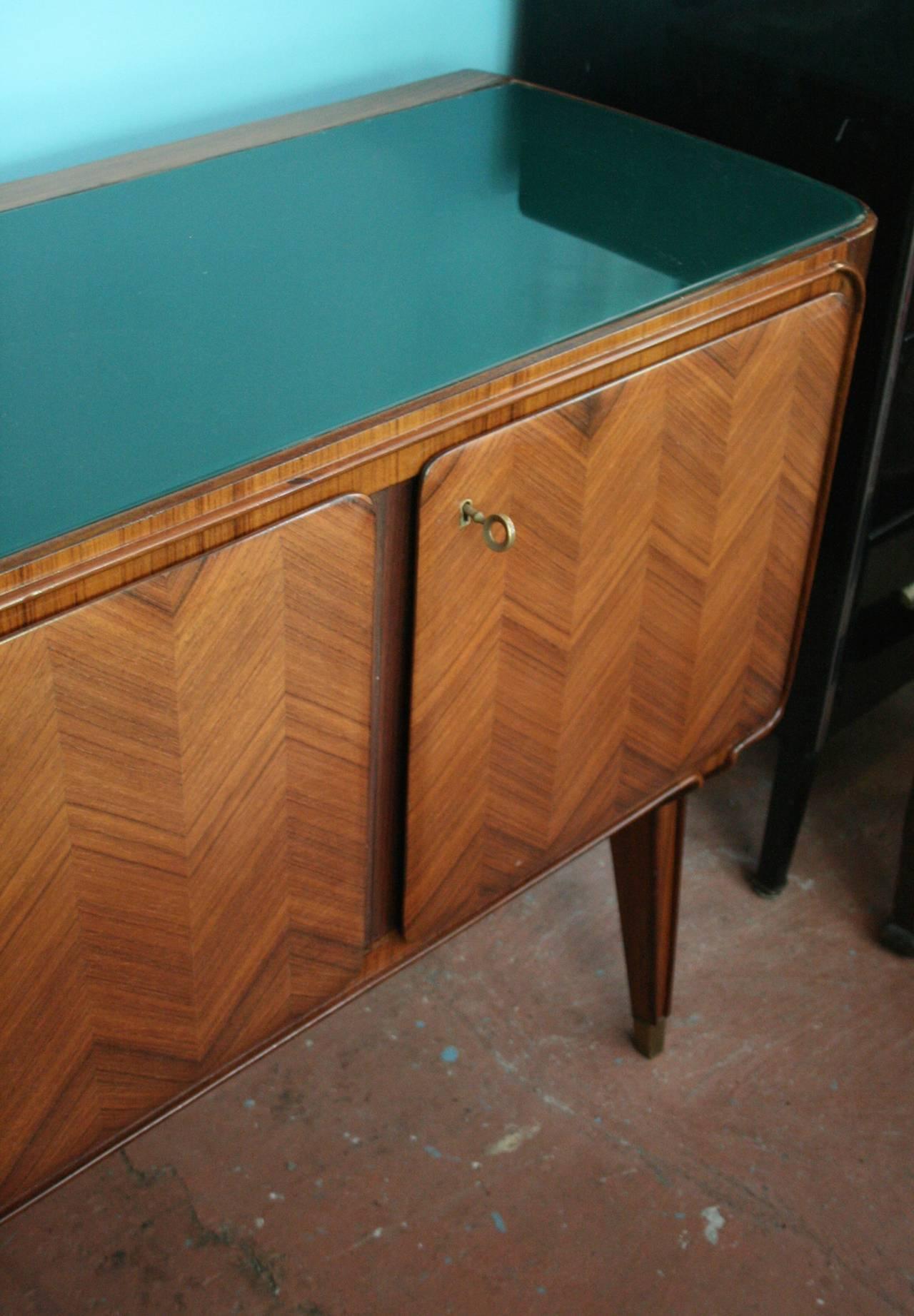 Beautiful rosewood sideboard by Dassi featuring five doors with inlaid herringbone pattern; central section features silver drawers; retains all original brass hardware on legs, pulls, locks and working key for all doors.

Avantgarden Ltd.