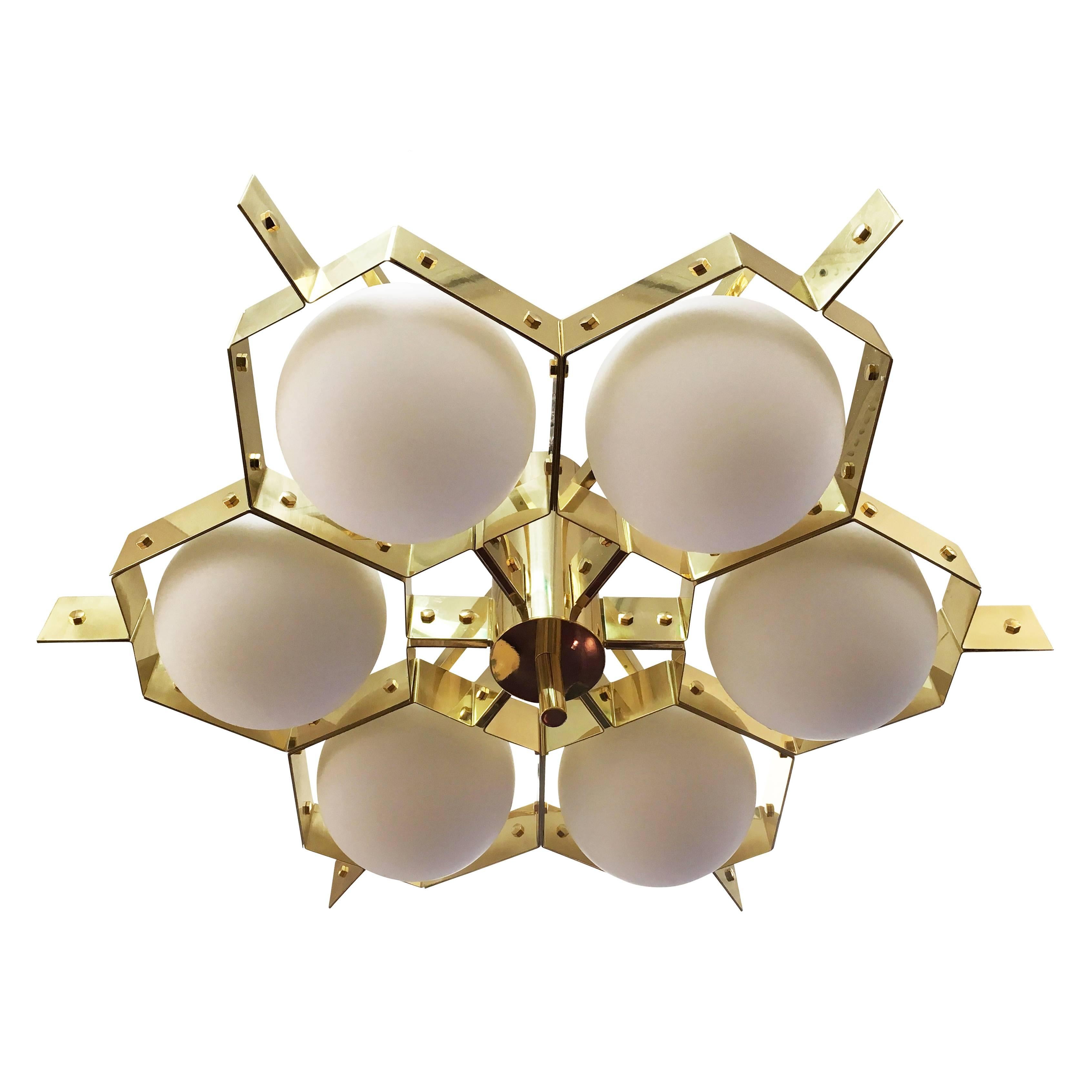 Brass lighting fixture with six frosted glass spheres encased in a bee hive-like structure. Designed in collaboration with Milanese Artist Fedele Papagni, it can be mounted as a flush mount or on a stem of any length. Can be customized in size and