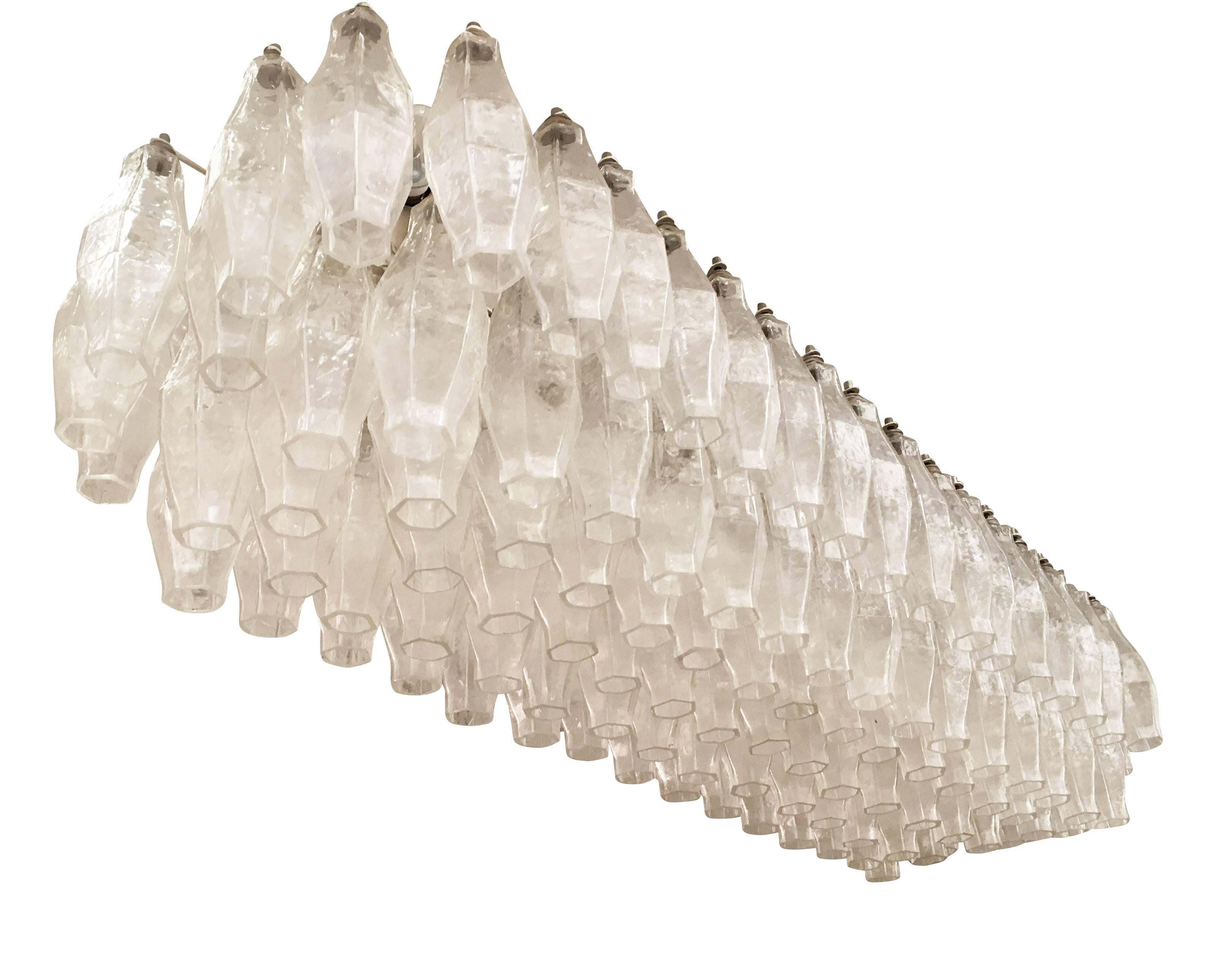Stunning elongated chandelier attributed to Venini featuring 119 clear polyhedral glasses. The white frame holds 12 candelabra sockets. Ideal over a dining room table or a long hallway. Can be hung from two chains or stems.

Condition: Excellent