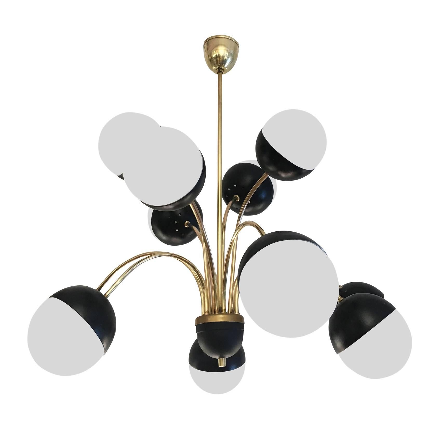 Beautiful chandelier featuring an irregular cascade of eleven white frosted glass globes. The brass structure and the arms are from 1950s while the aluminum and glass shades were a later addition. Holds eleven candelabra sockets.