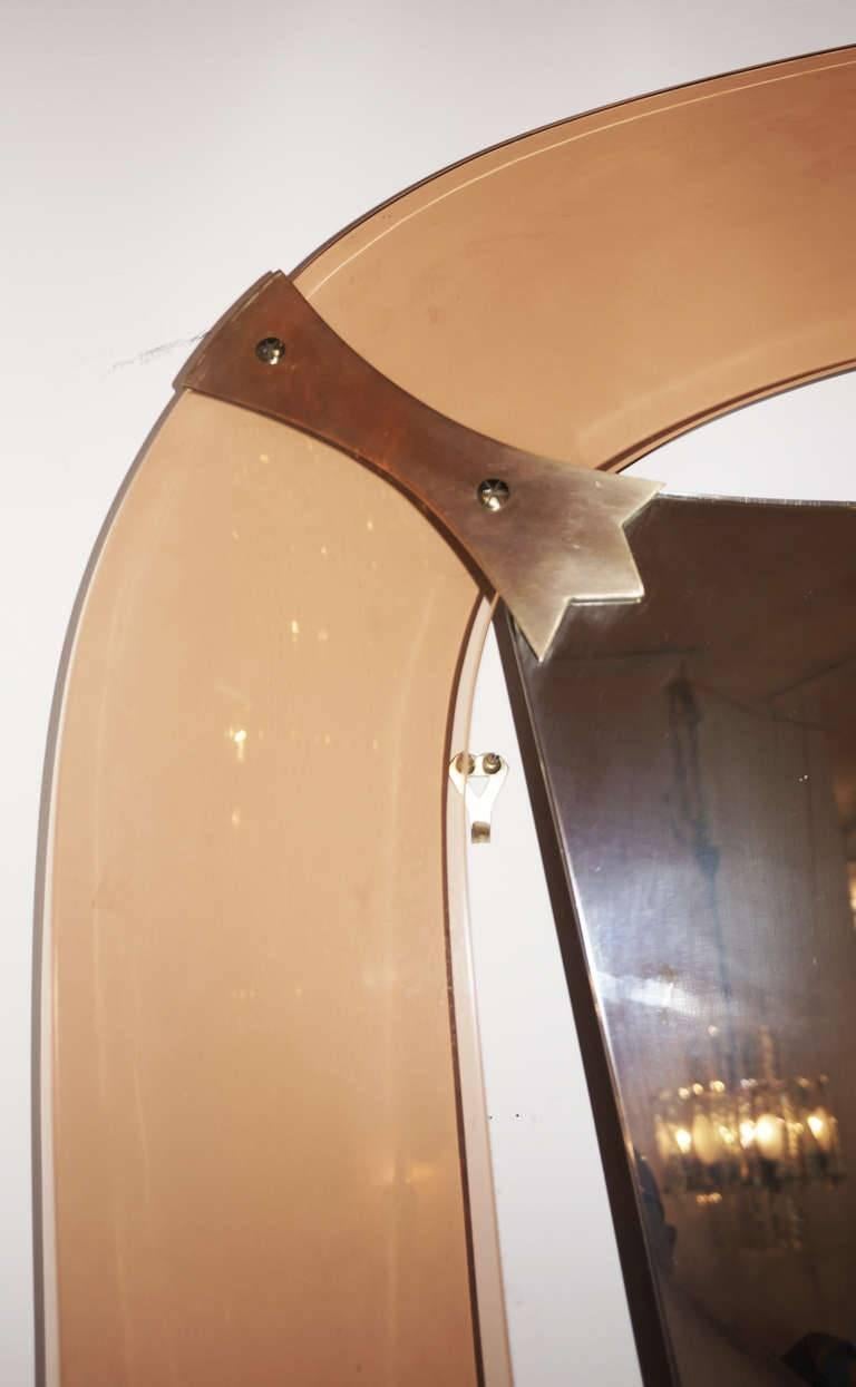 As one of the greatest of all Crystal Art designs it features a reversed tear drop shaped mirror with a salmon color frame. A thick glass shelf completes the piece. It has a foot rest and can be anchored to the wall. At auctions it has reached