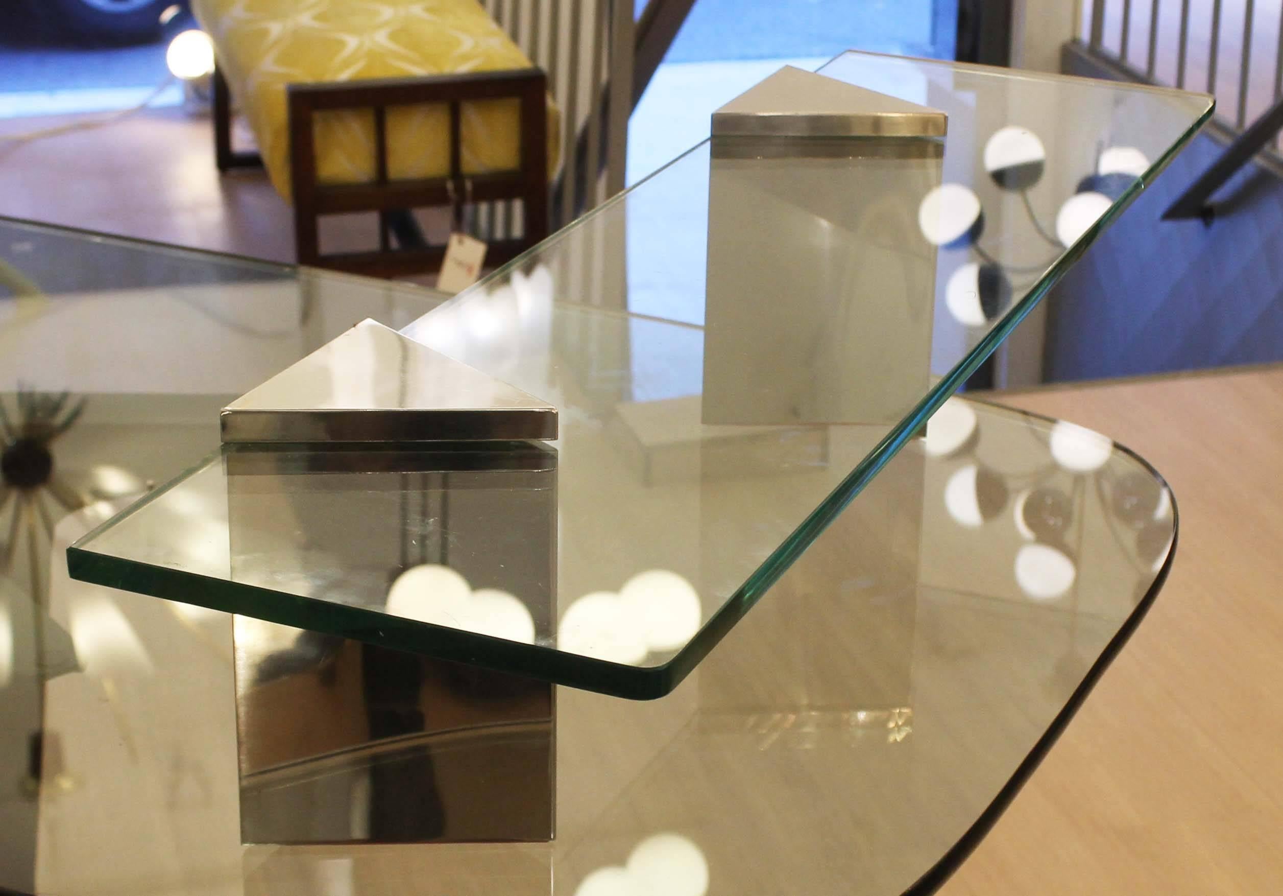 Sleek console by Cristal Art. Composed of a thick glass top supported by two chrome triangular structures.