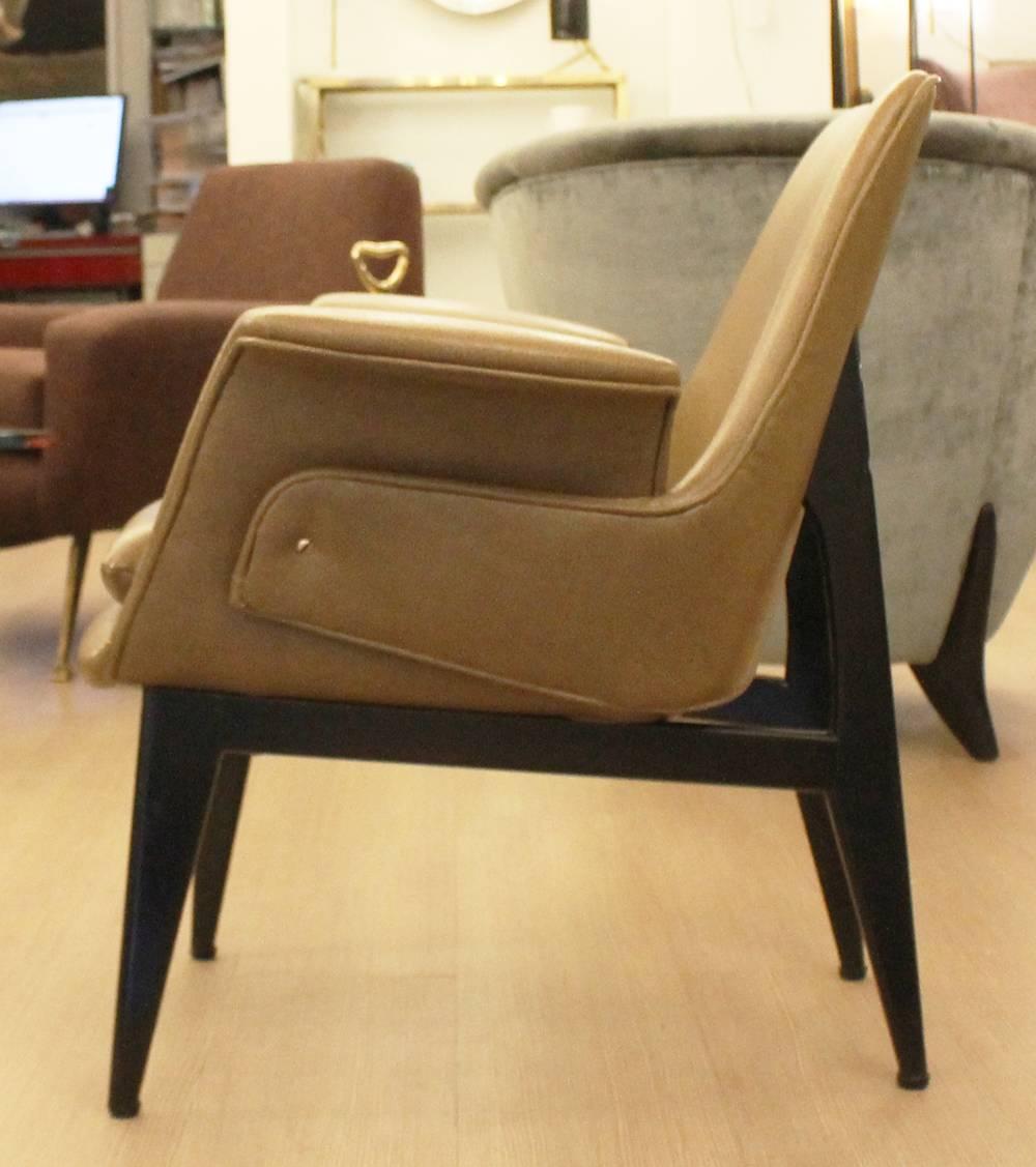 Unique pair of lounge chairs featuring a back that embraces the seat and arm rests. 

Some wear to the faux leather-will need to be recovered 