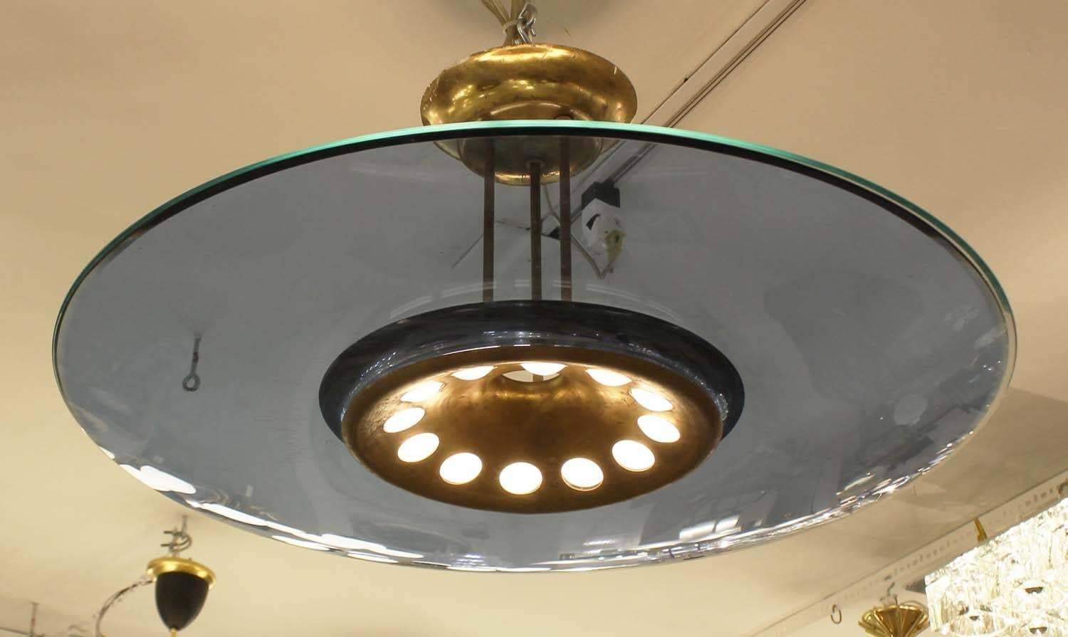 Beautiful Fontana Arte Chandelier model 1508 designed by Max Ingrand composed of a blue concave glass shade and clear glass top. The glass top creates the acqua color edge and prevents dust from settling on the blue shade. The frame is brass and