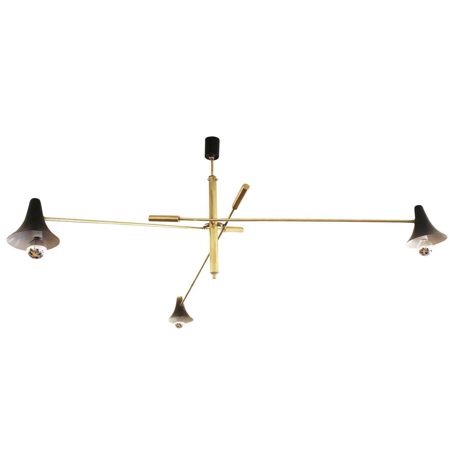 Adjustable arm chandelier featuring brass hardware and black shades and canopy. The slim stems give a light feeling to the fixture. Holds three candelabra sockets. Height of stem can be adjusted upon request.

Condition: Excellent vintage