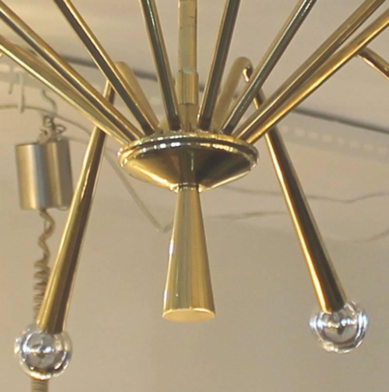 This large brass fixture has 12 arms with candelabra sockets. Possibly designed by Angelo Lelli for Arredoluce. Can be modified to have the arms pointing upwards upon request. Height of stem can be changed upon request.
