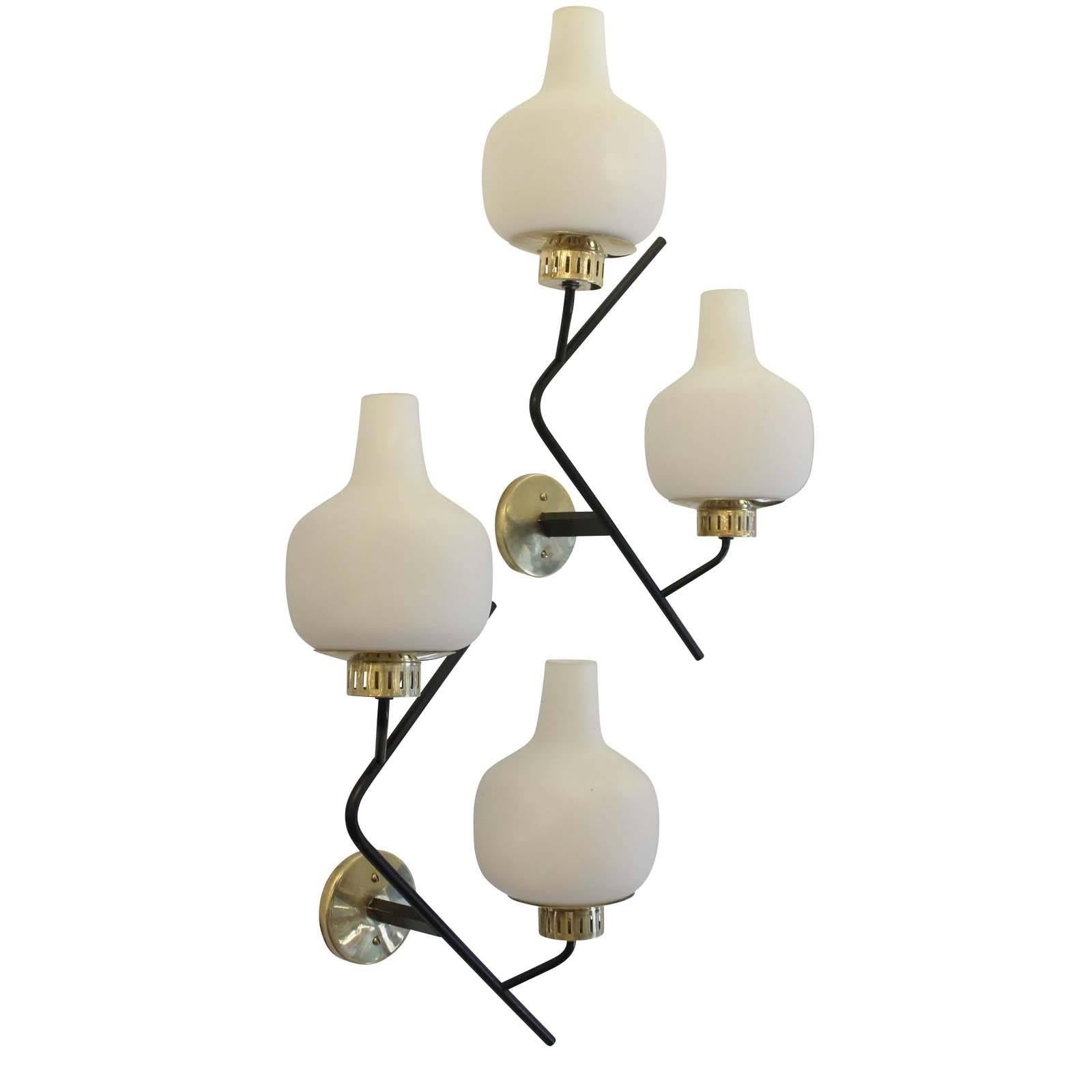 Large pair of Stilnovo attributed sconces each featuring two frosted glass shades on a brass frame. The brass frame is painted black in certain areas. Each holds two candelabra sockets. Back plate to mount to American electrical box included.