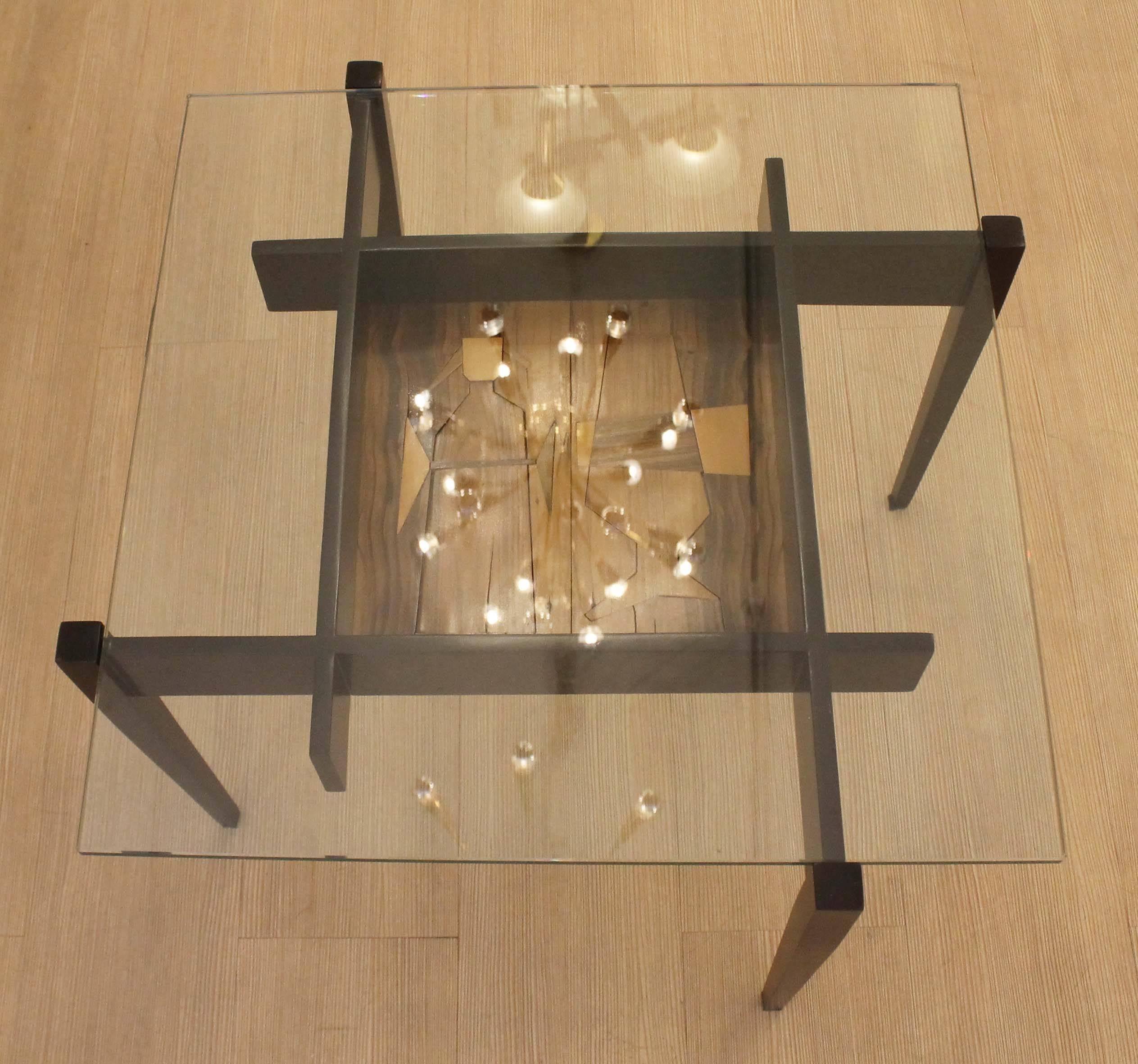 Playful wood table with glass top. At the center there is a decorative cocktail themed etching.
