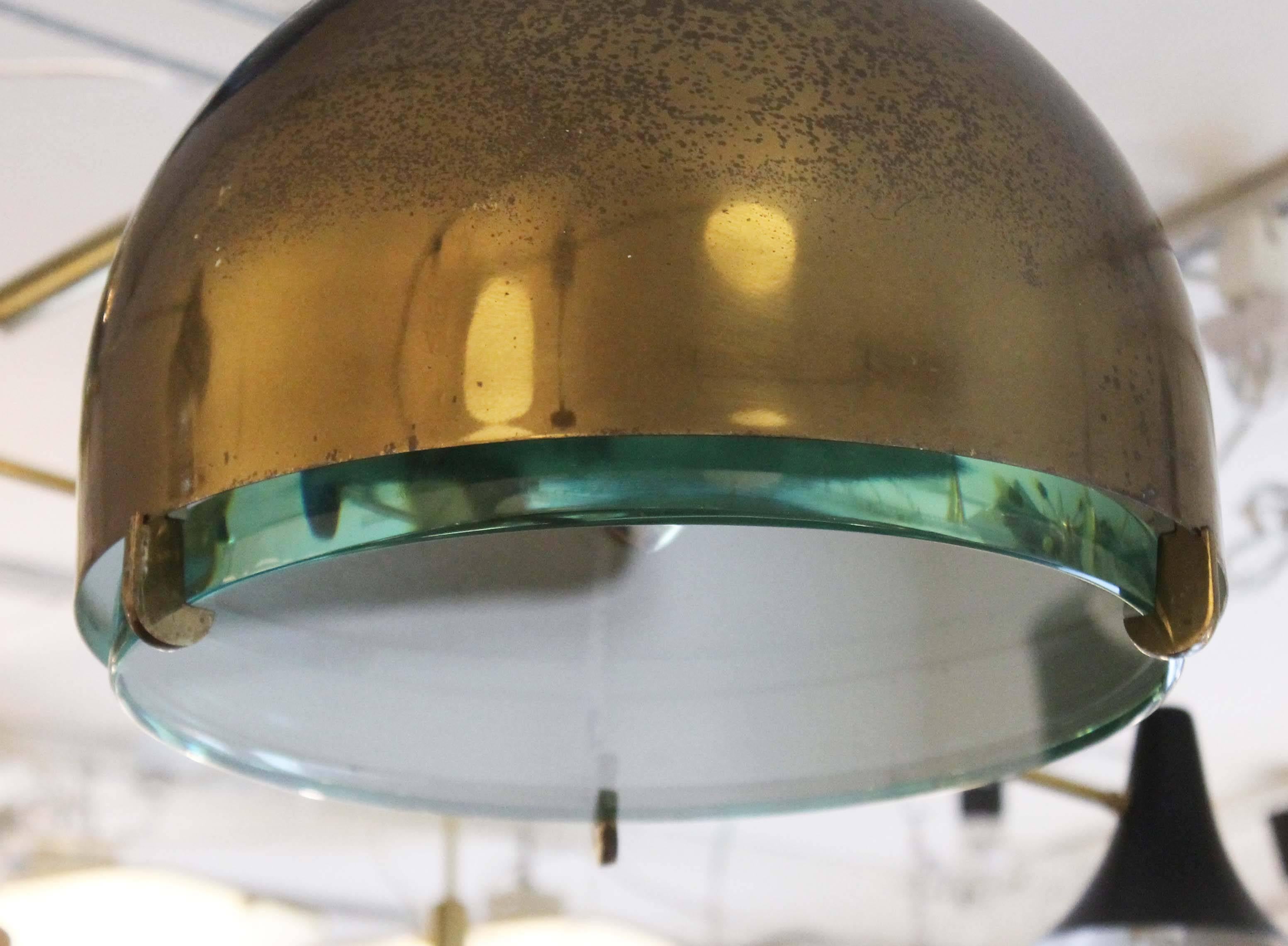 Beautiful and rare Fontana Arte pendant designed by Max Ingrand featuring a thick glass screen and patinated brass mounting. Height can be easily adjusted by shortening or tightening the electrical cord. Holds one regular Edison socket. The brass