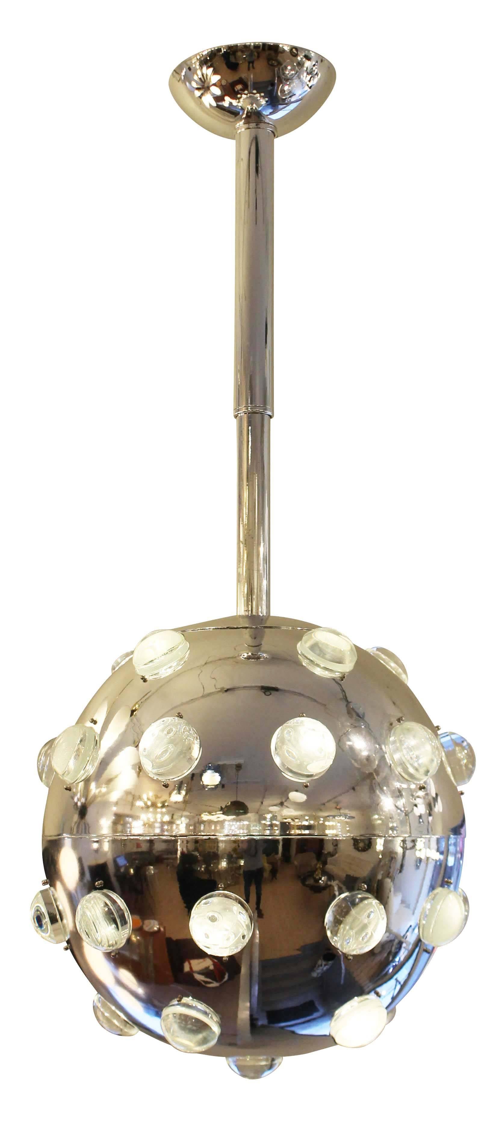 Impactful chrome pendant covered by glass studs through which light is diffused. Hangs on a telescopic stem which can be extended 14 in. for a total possible height of 63 in. Possibly manufactured by Leucos. Holds ten regular sockets.
