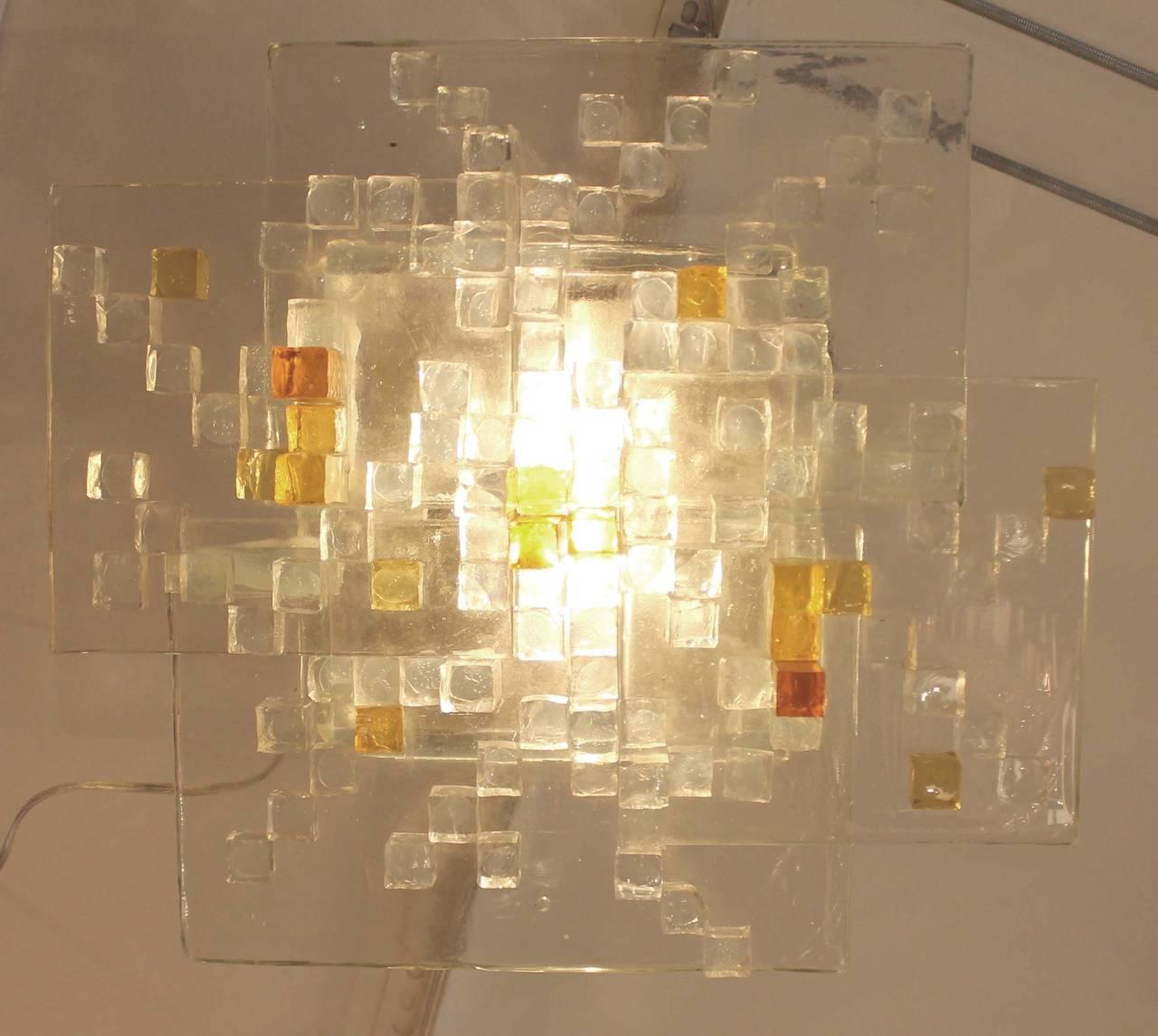 Ceiling light composed of four thick glass slabs with protruding "broken" clear and amber glass cubes. This is a typical example of the creativity of Poli, the creator of Poliarte, who often employed the technique of gluing together