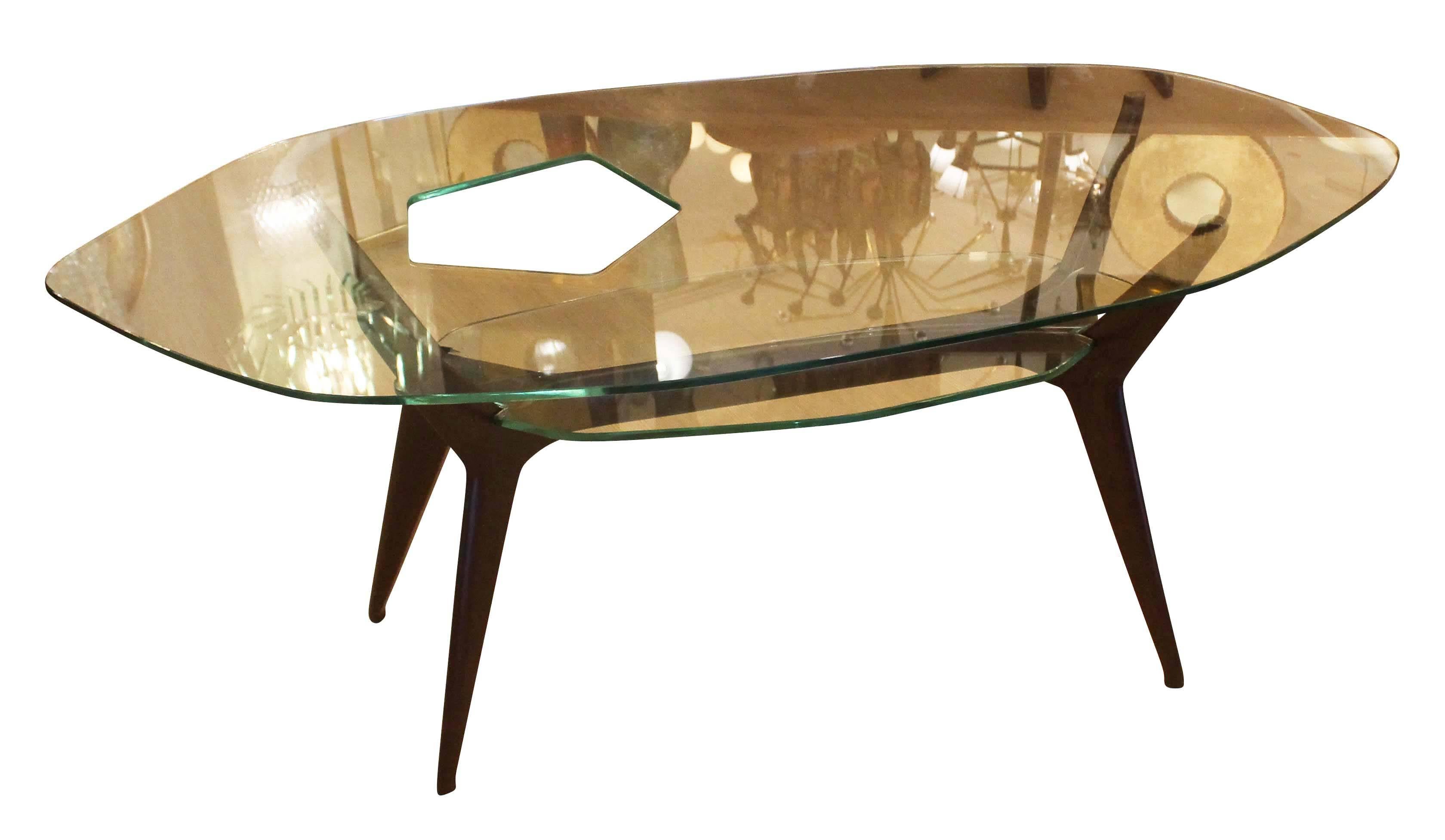 Beautiful and unusual coffee table in the style of Ico Parisi featuring two clear asymmetrical glass tops. The larger top has a hole which is also asymmetrical and organic in shape and location.
