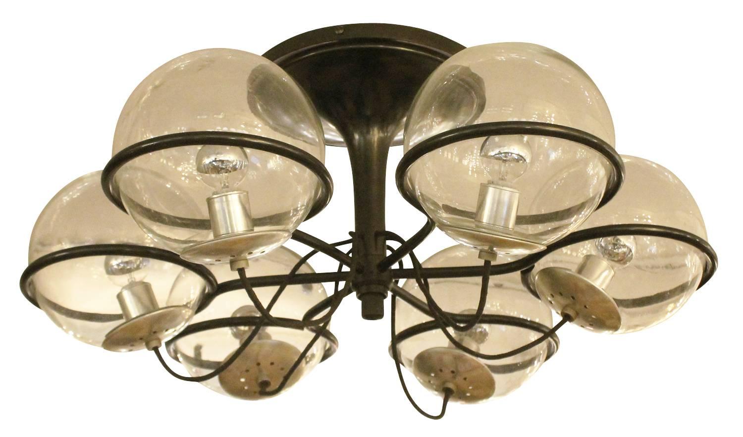 Six globe Arteluce chandelier designed by Gino Sarfatti in 1963. The globes are clear and the frame is black painted metal. Original label still present. Sconces and three globe chandeliers of the same series are also available.

Available for