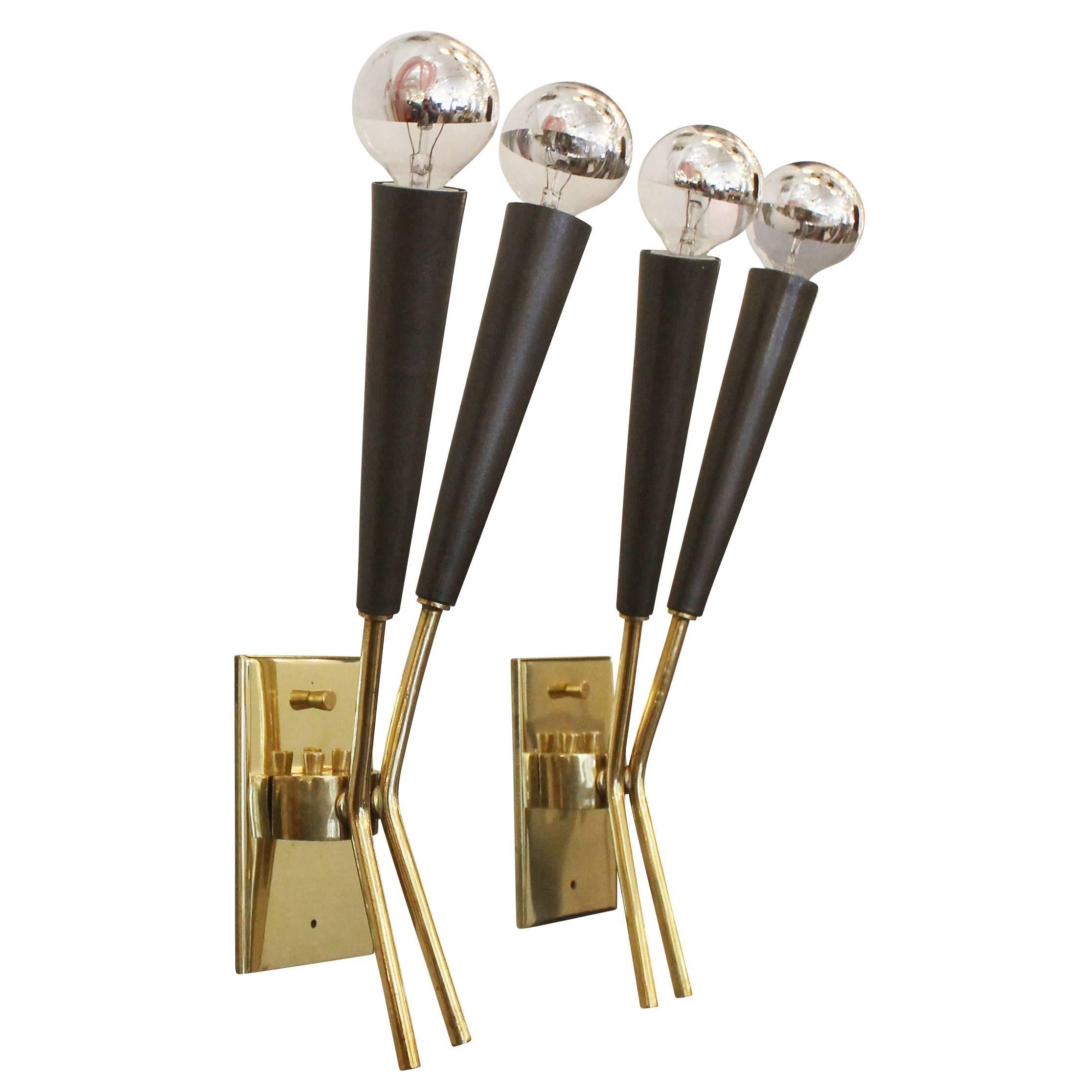 Sleek pair of wall lights in the manner of Stilnovo. The frame is brass and the diffusers gun metal painted aluminium. Each holds two candelabra sockets.
