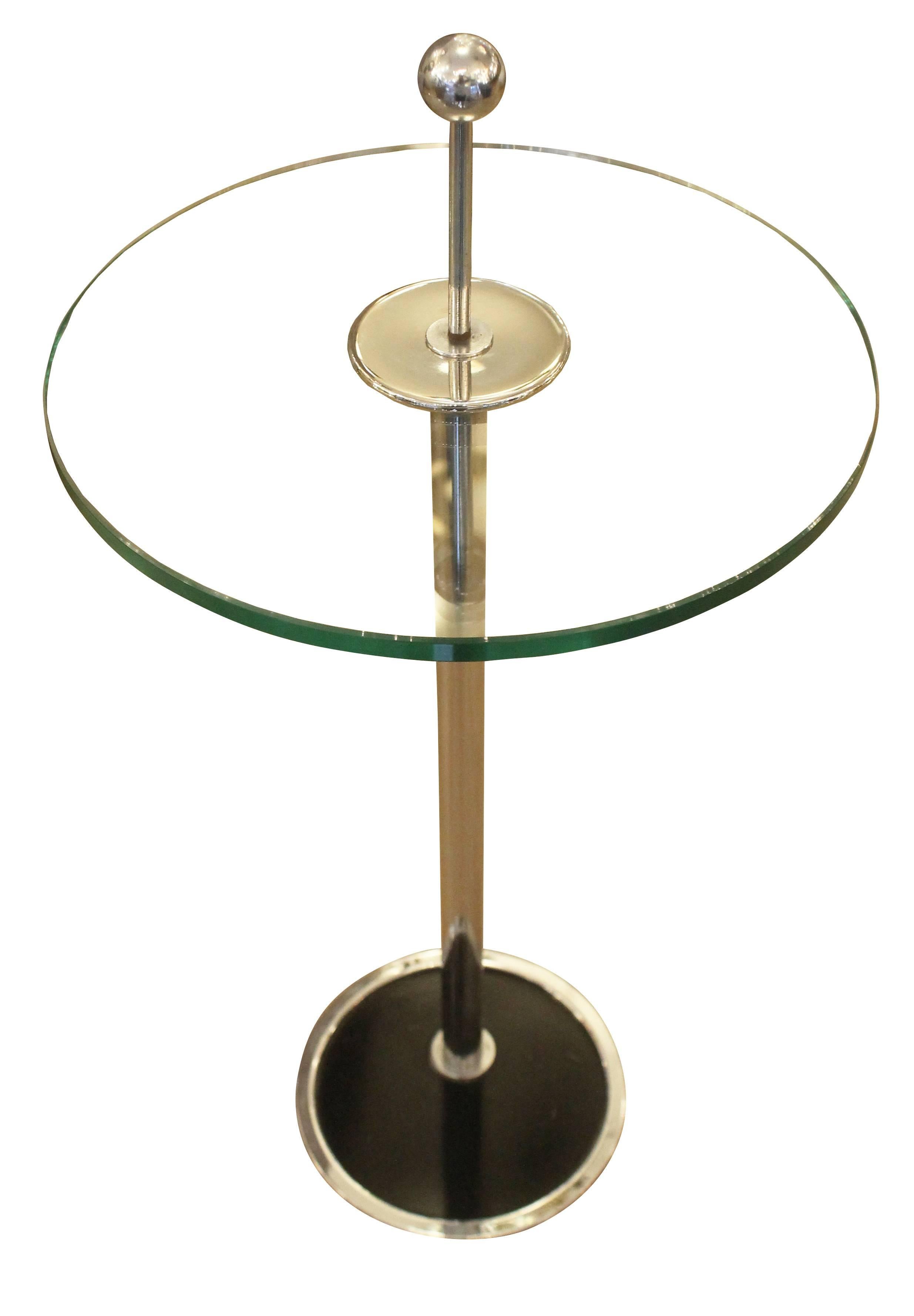 Diminutive chrome side table with an off center base and round glss top. Ideal next to a lounge chair or sofa.
