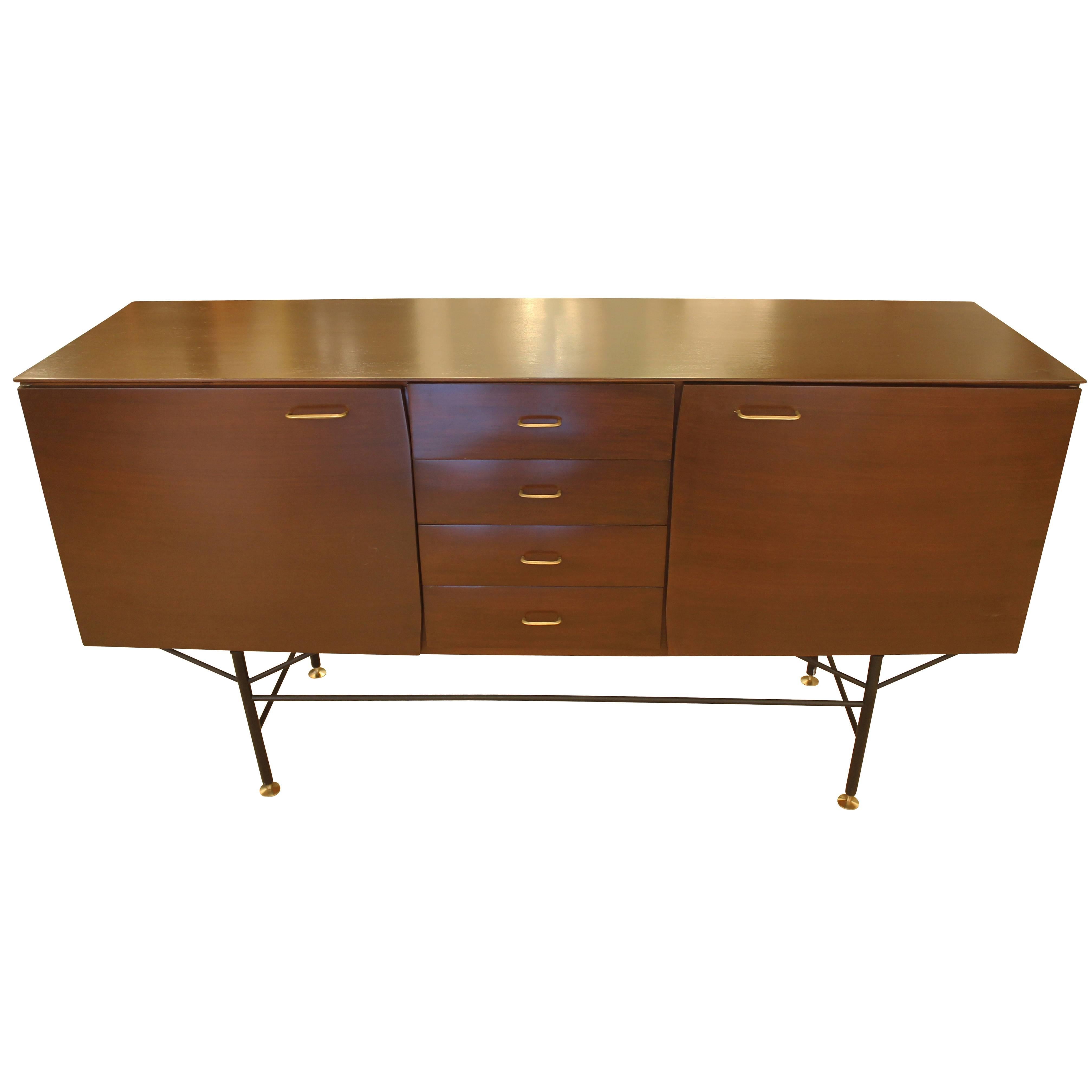 Exceptional Mid-Century Italian credenza made with a rosewood veneer. It has two large cabinets at the sides and four drawers at the center. The legs are black lacquered metal while the feet and handles are brass.
