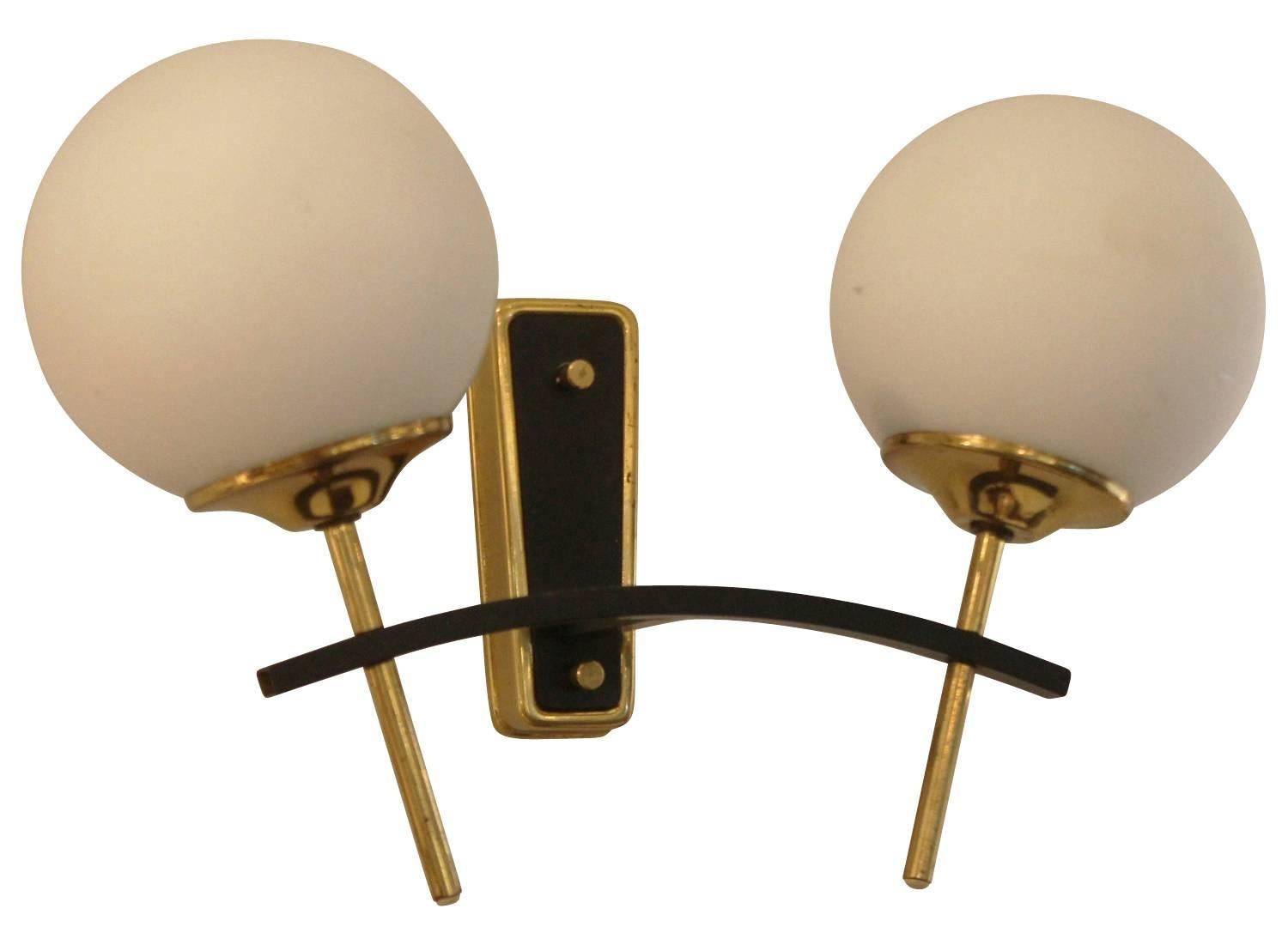 Exquisite pair of Stilnovo style sconces each holding two round frosted glass shades. The frame is brass and lacquered black in some sections.

Available for viewing at Gaspare Asaro-Italian Modern in NYC